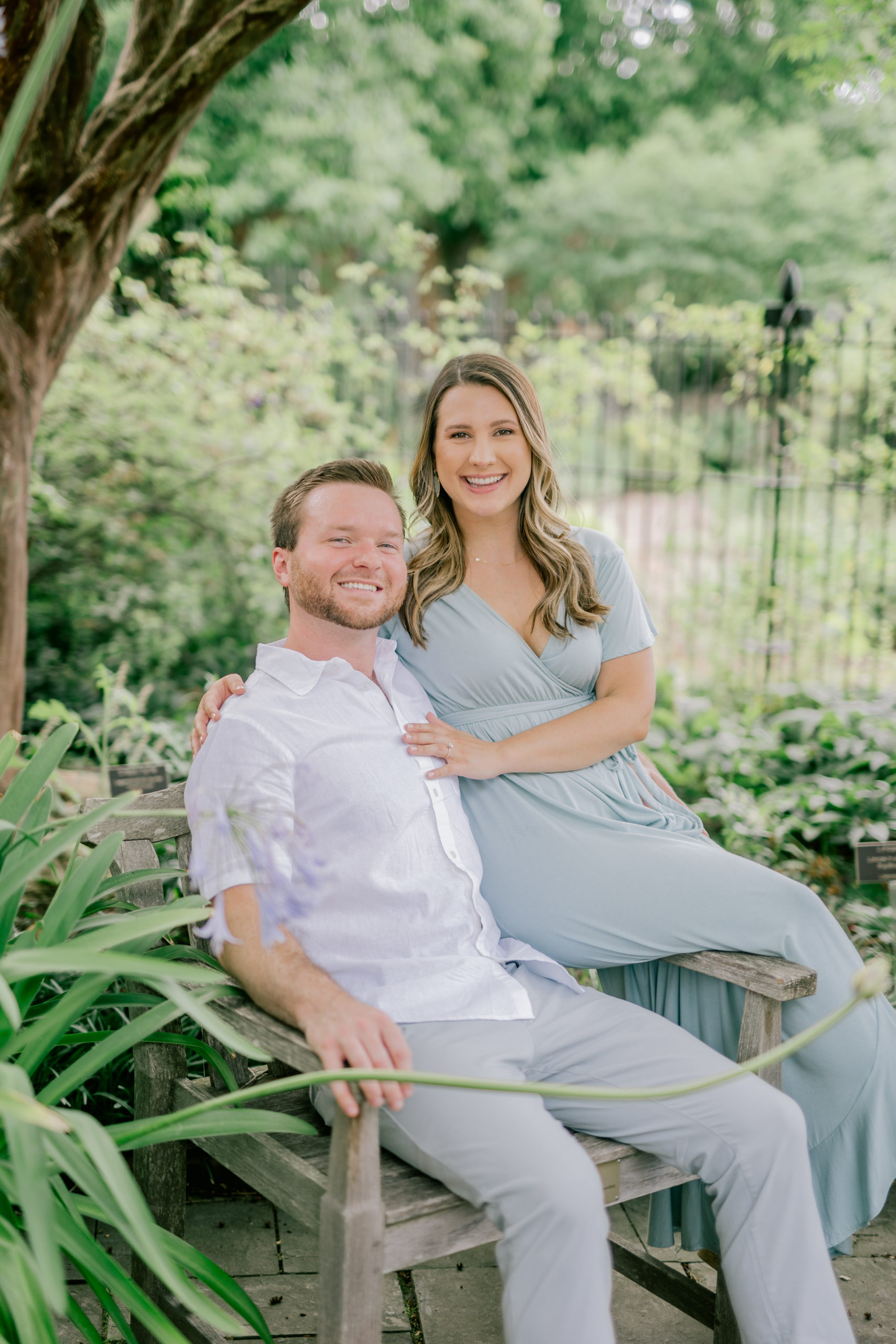 Couple sitting on a chair in a garden - Lewis Ginter Botanical Garden Engagement Session - Garden Engagement Session