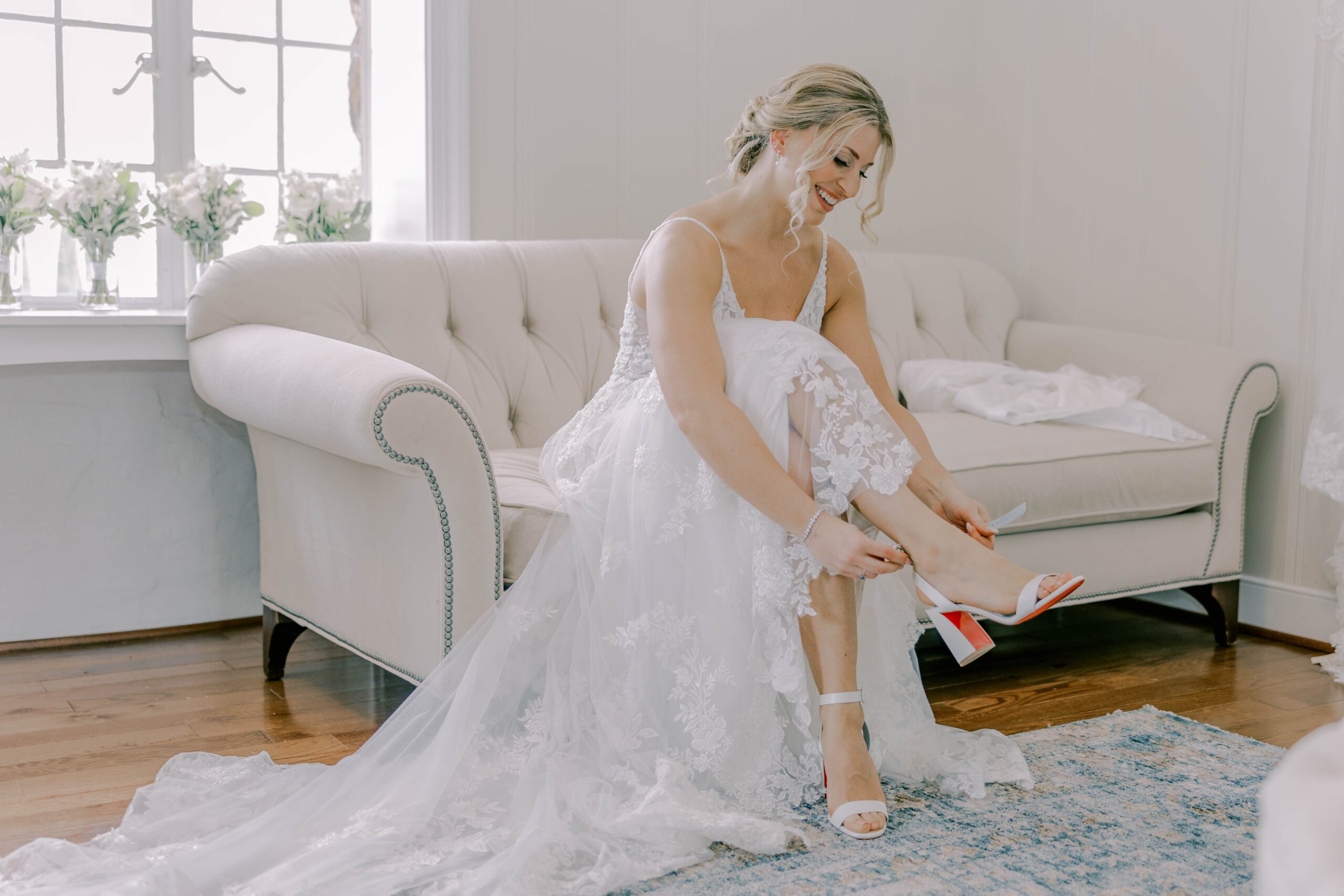 the bride prepares for her wedding day by putting on a shoe.