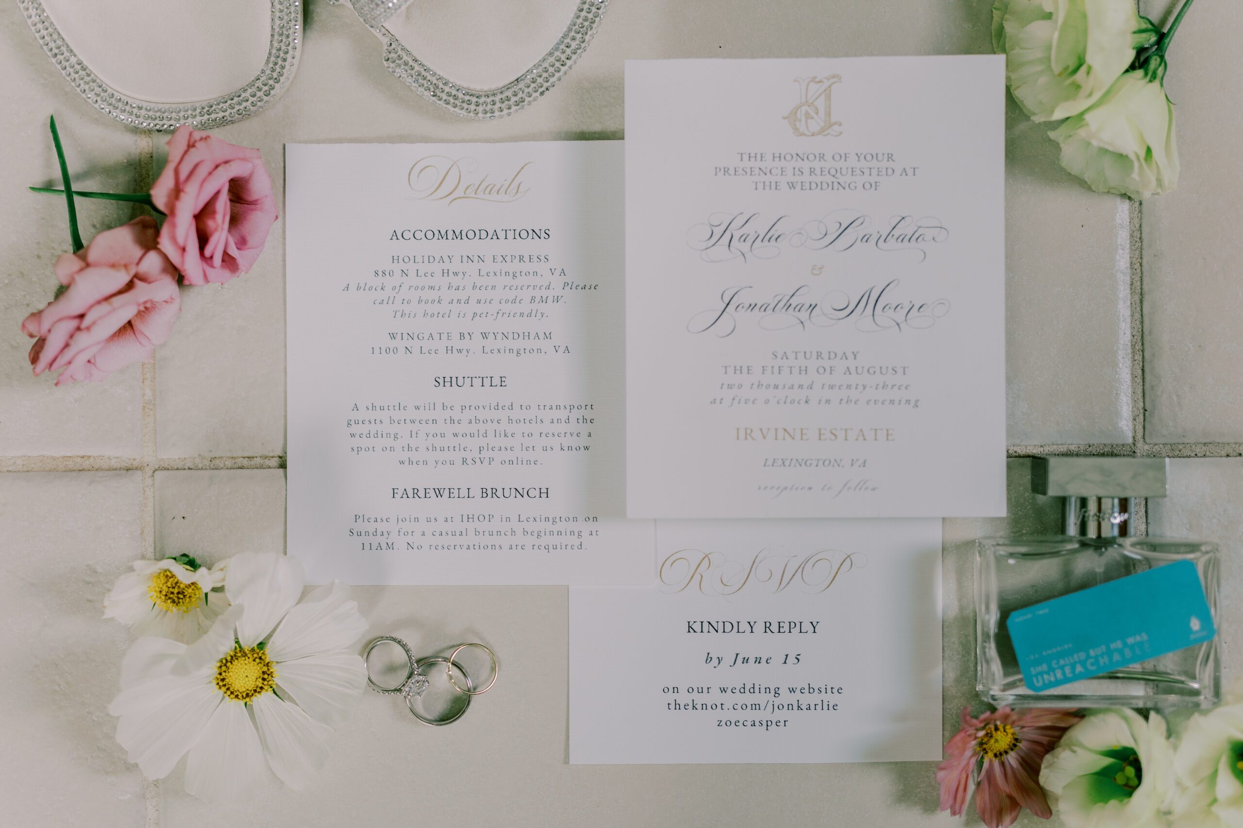 Detail photo of wedding invitation, detail page and rsvp card, florals, perfume and jewelry placed around them