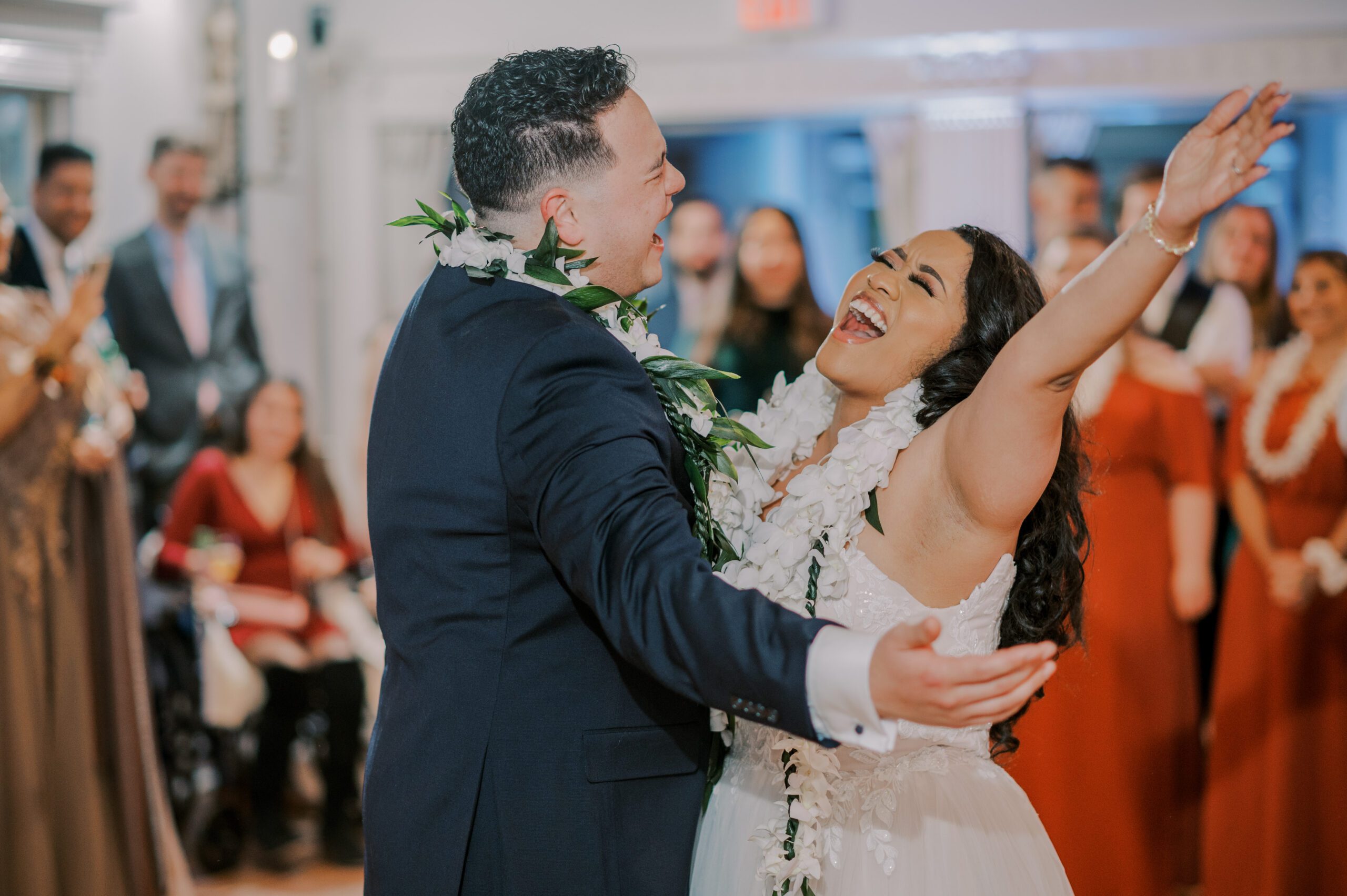 Bride and groom dancing, both singing passionately while bride throws her arm up in the air