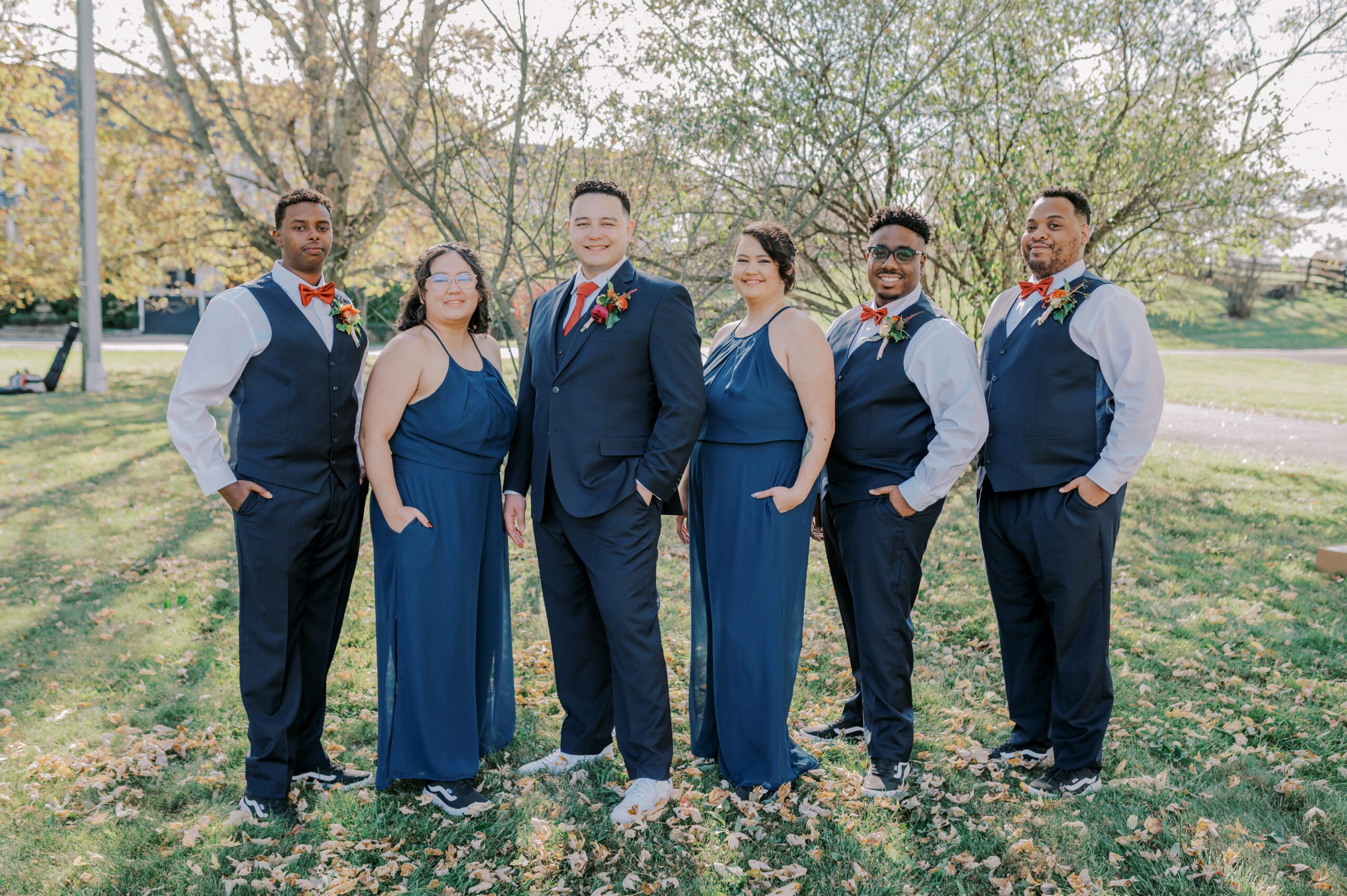 Groom and his wedding party members, three men in suits and two women in blue jumpsuits