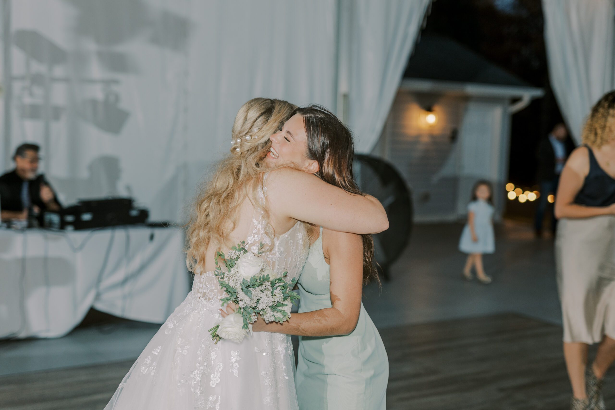 Bride hugging bridesmaid that caught the bouquet at her arbor haven fall wedding
