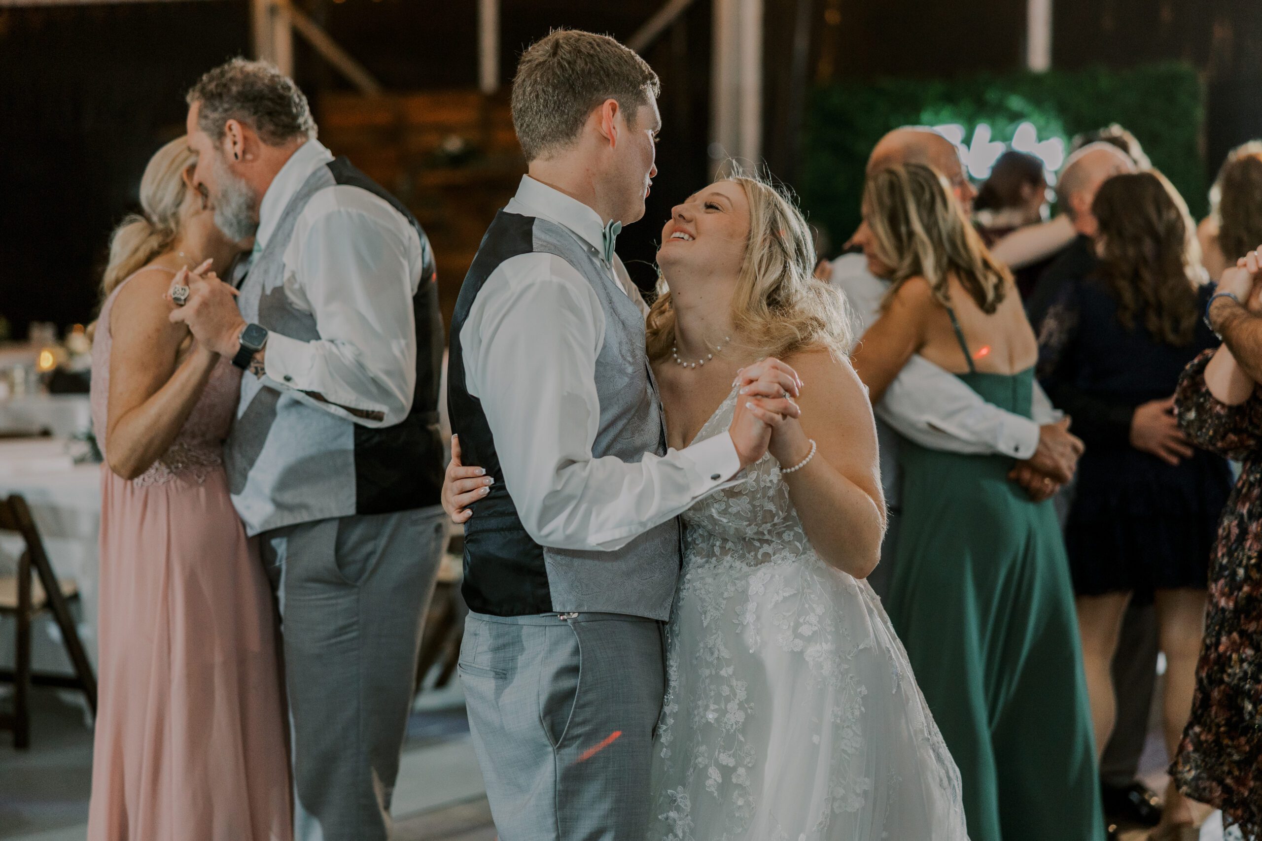 Bride and groom slow dancing alongside other couples on the dance floor at their arbor haven wedding
