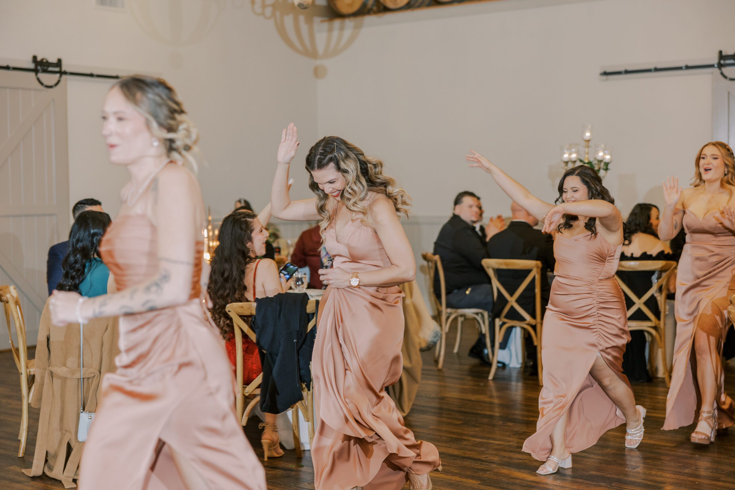 Bridesmaids enter reception dancing, running, laughing at king family vineyards wedding