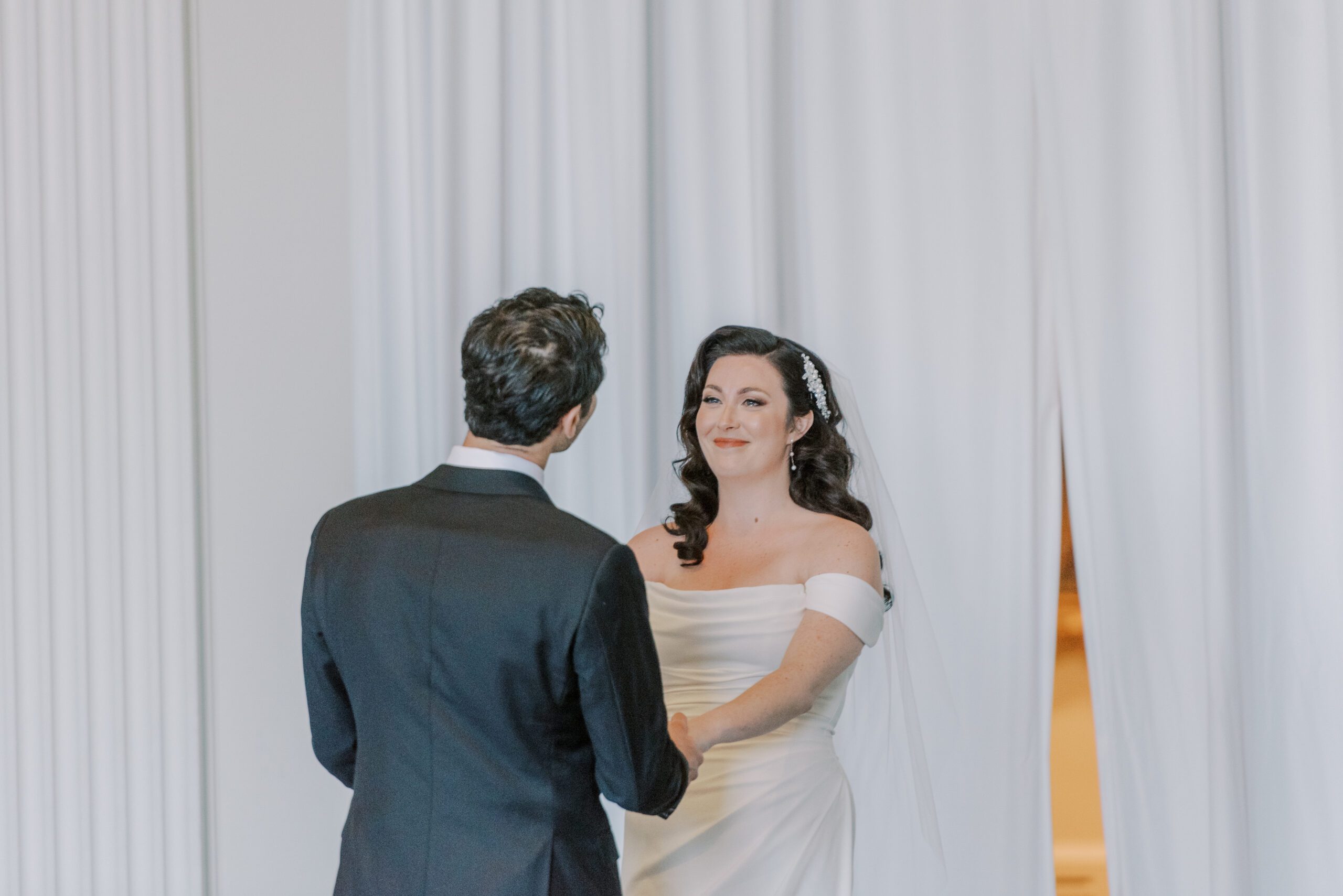 Emotional photo of bride as she sees the groom face to face for the first time on their wedding day at vmfa, groom facing away from camera to look at bride