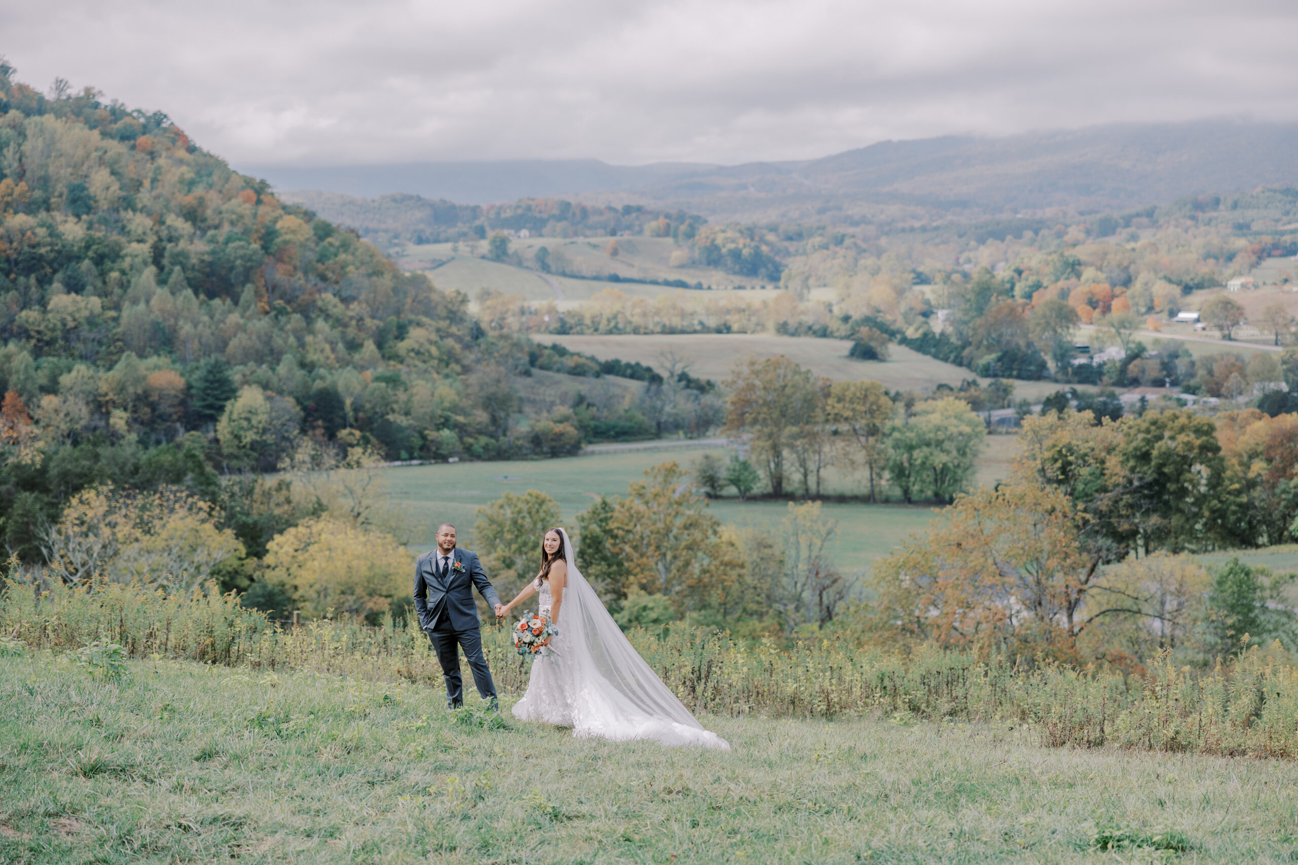 the bride and groom pose in front of the beautiful landscape at Big Spring Farm