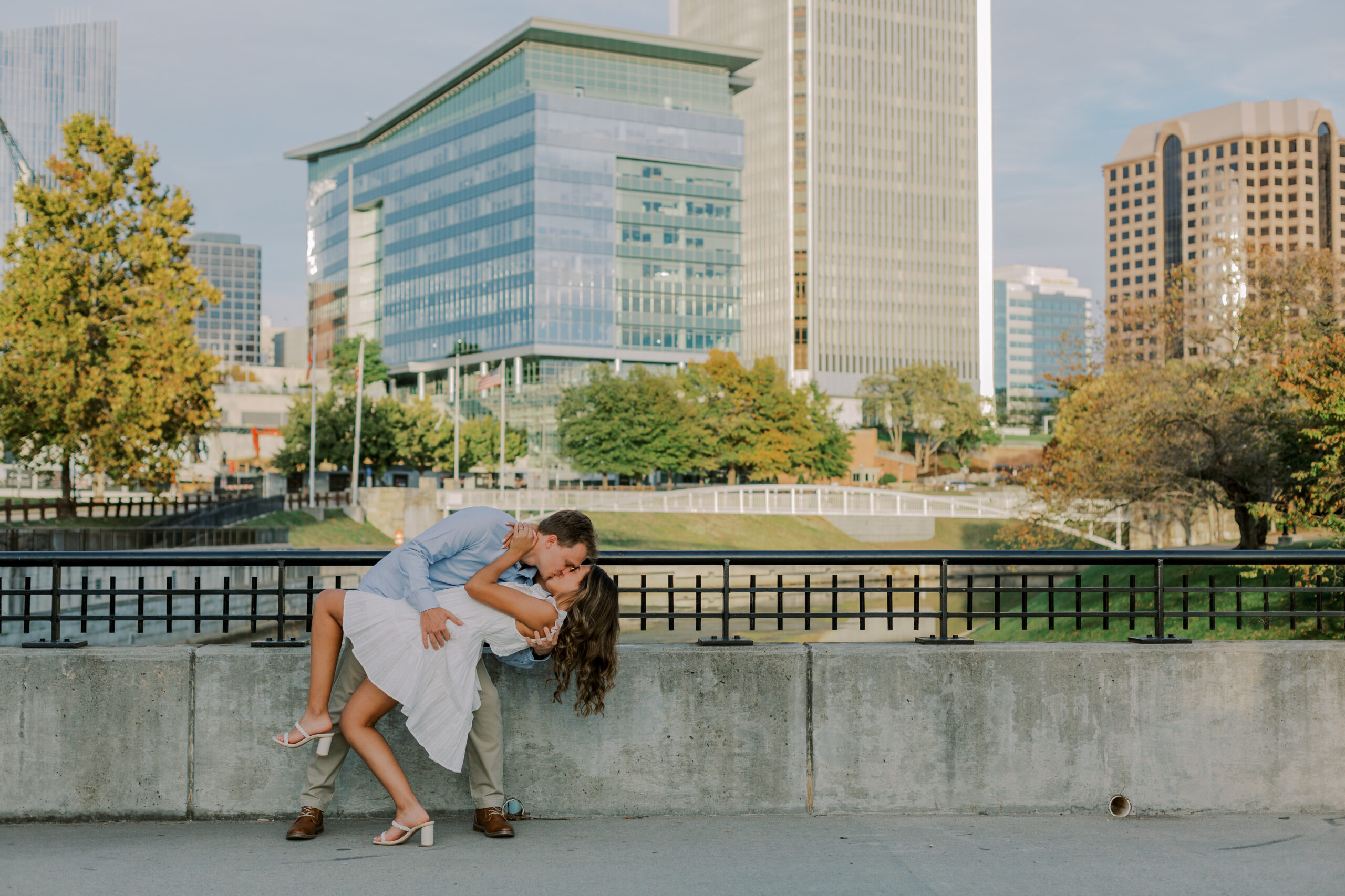 Man dipping woman, sharing a kiss overlooking buildings in the city of richmond, va