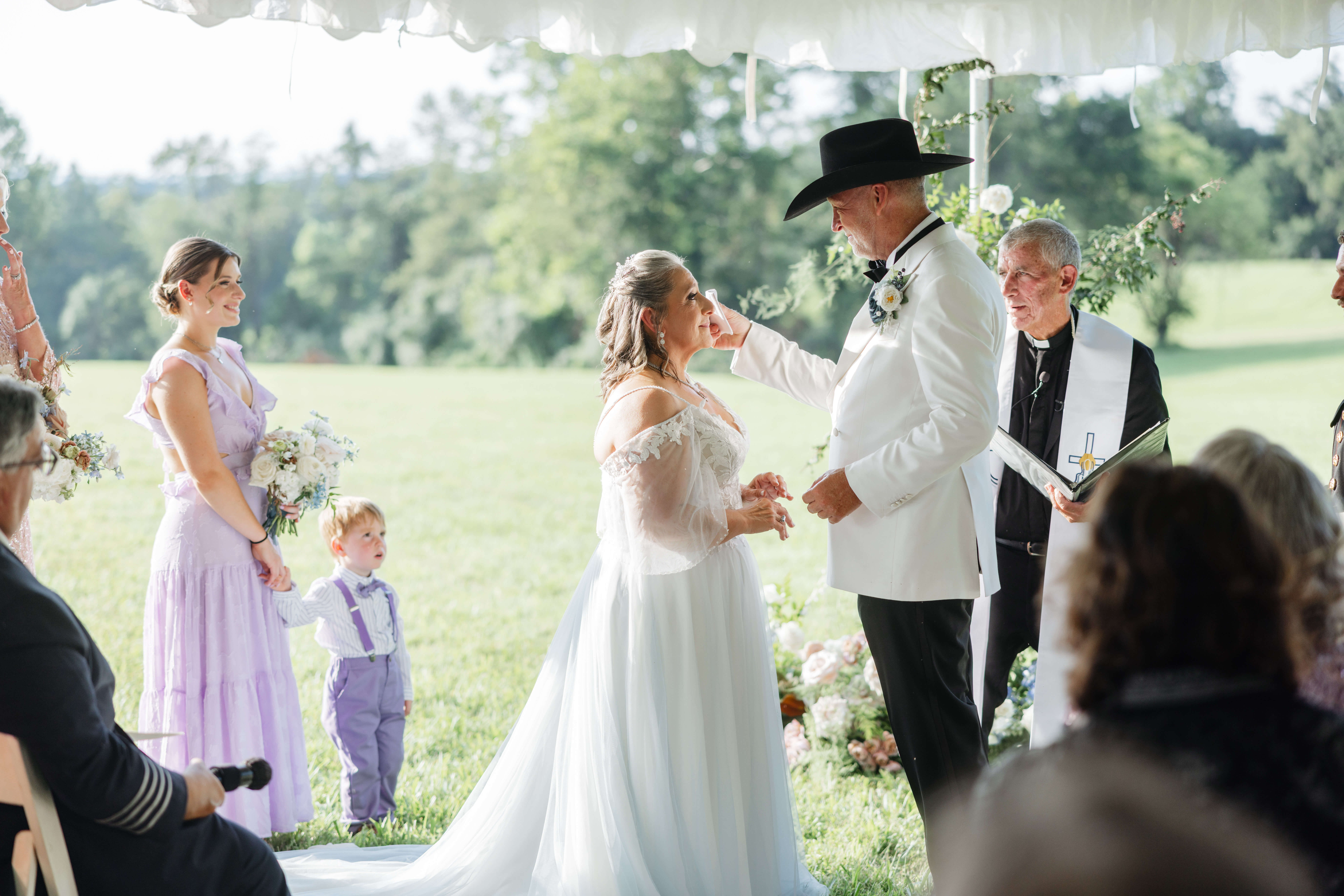 Private Residence Summer Wedding 19 Groom wiping a tear from the bride's face as they smile at one another