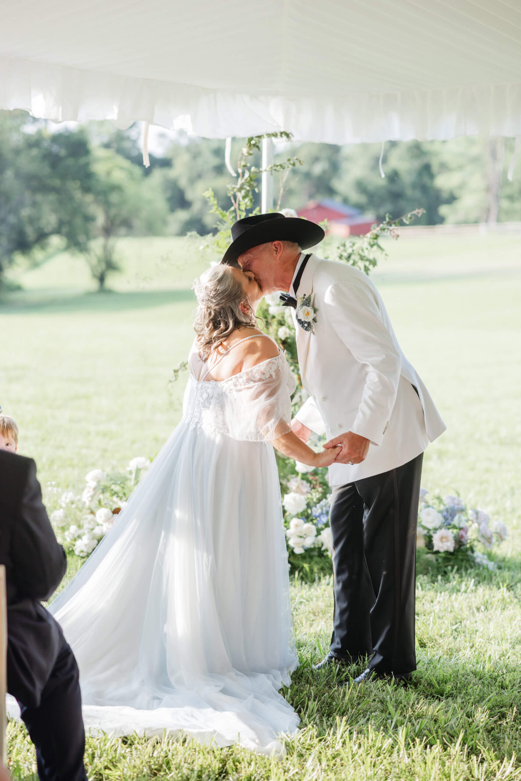 Private Residence Summer Wedding 21 Bride and groom share first kiss as husband and wife