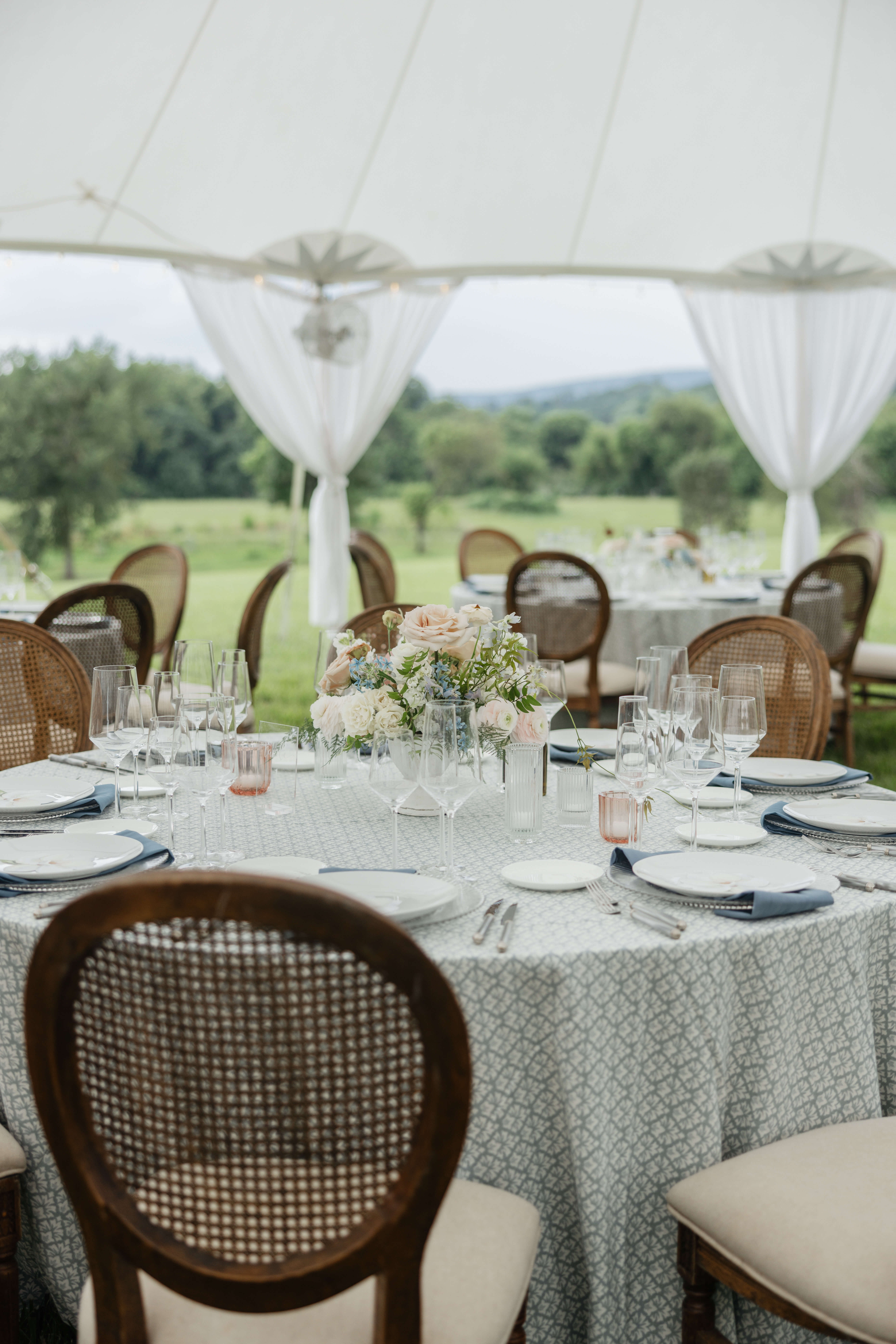 Private Residence Summer Wedding 5 Tables set up outside under tent with wooden chairs