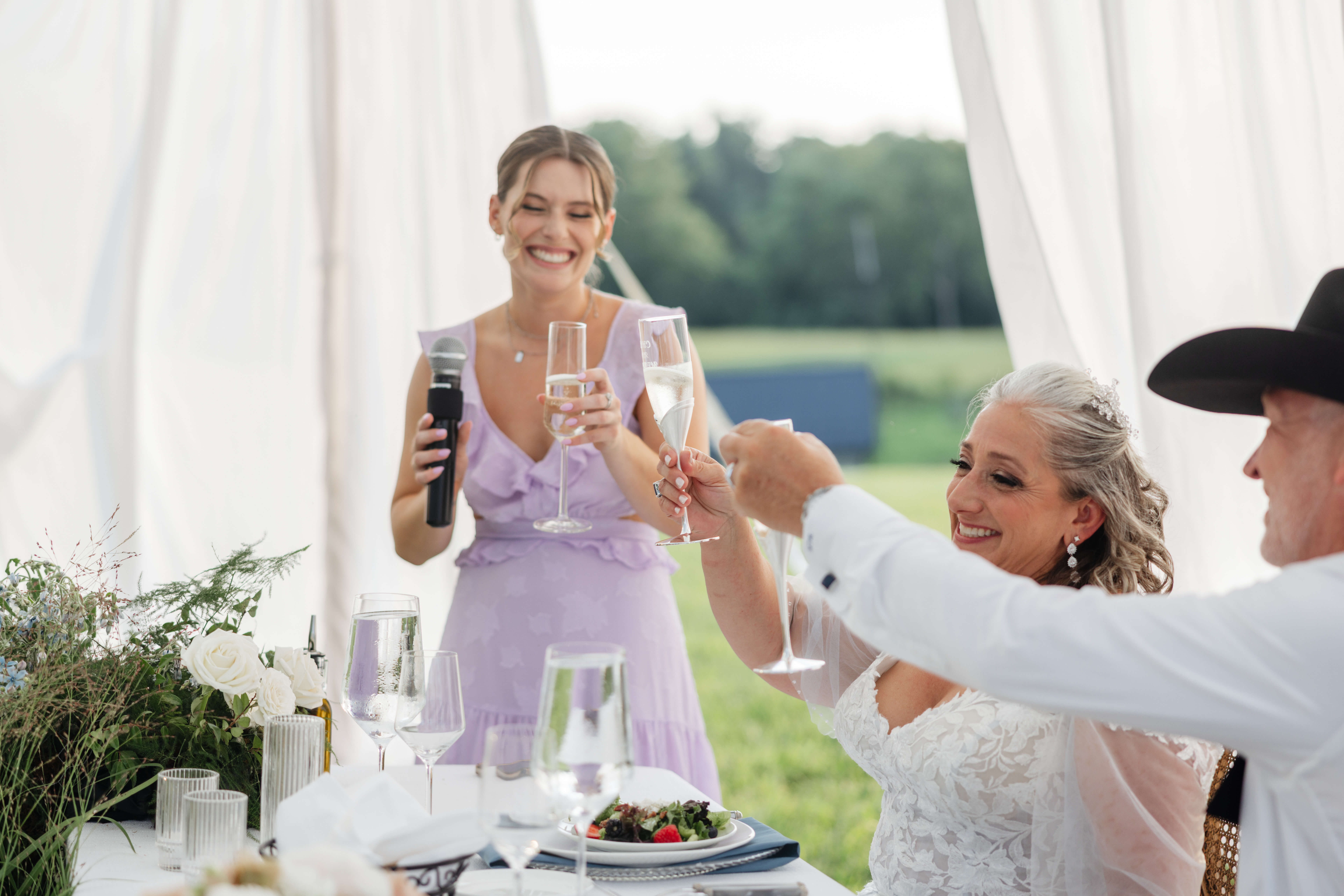 Private Residence Summer Wedding 33 Bride and groom toast with young woman giving speech