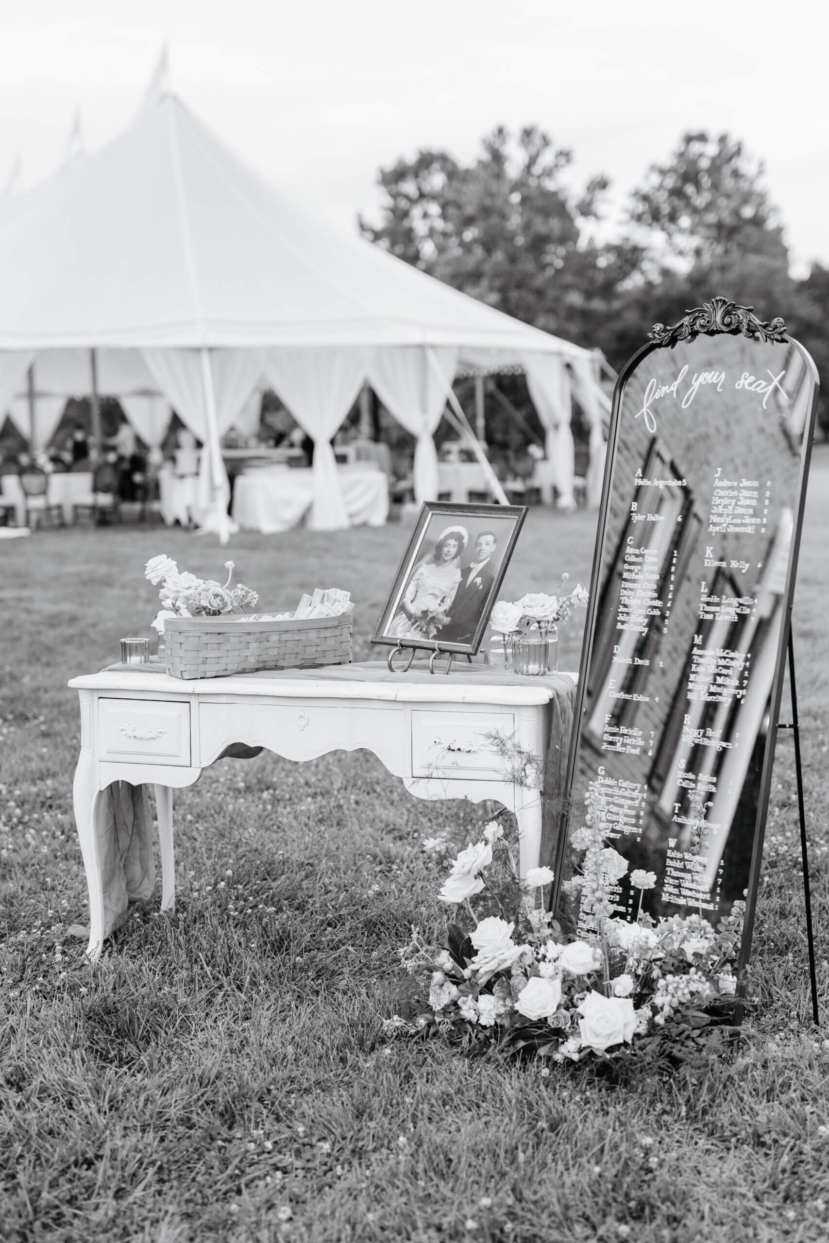 Private Residence Summer Wedding 7 Black and white photo of large mirror with seating chart, and a vintage dresser with some decor on it