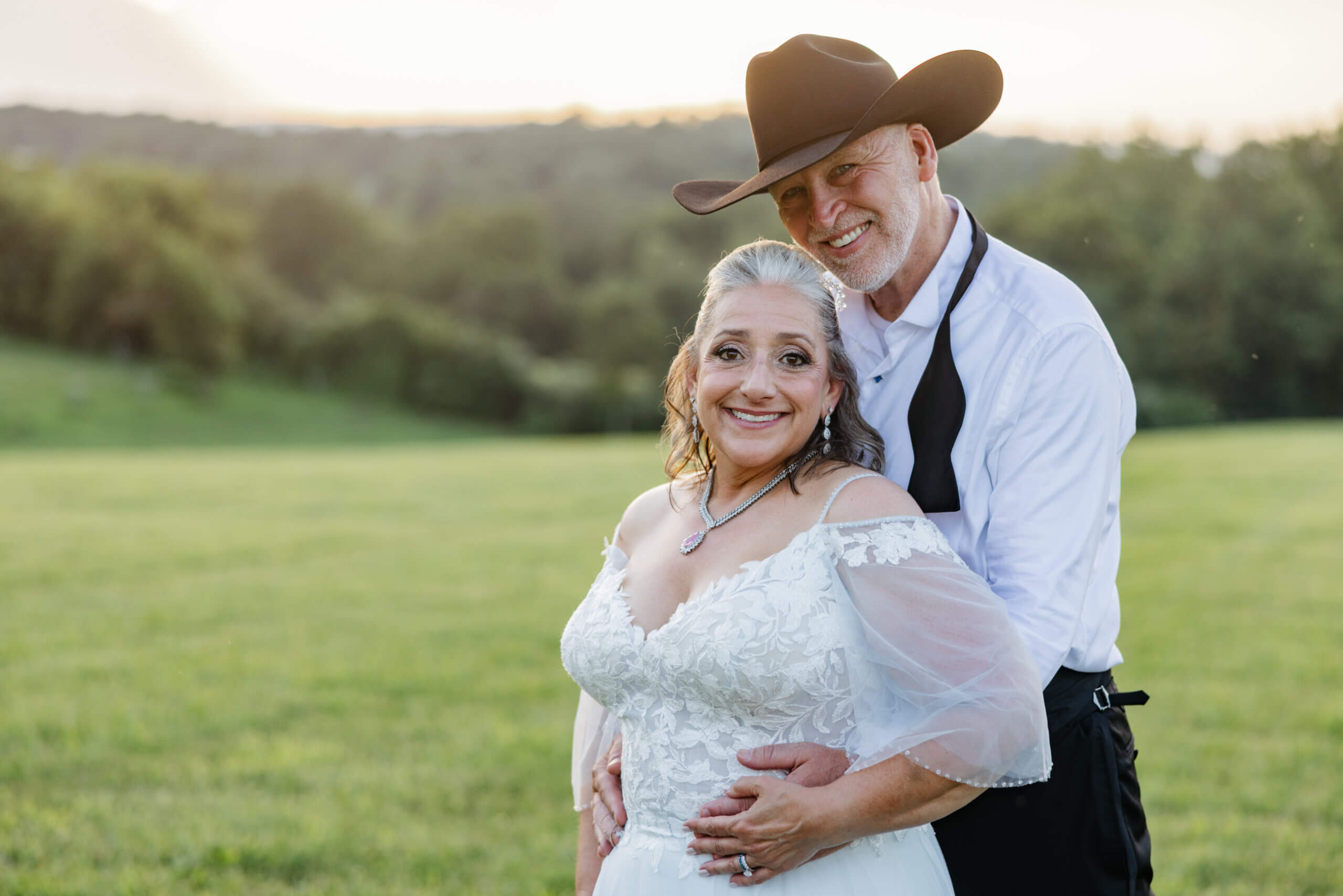 Private Residence Summer Wedding 35 Close up photo of bride and groom both smiling at camera, sunset and greenery landscape in background