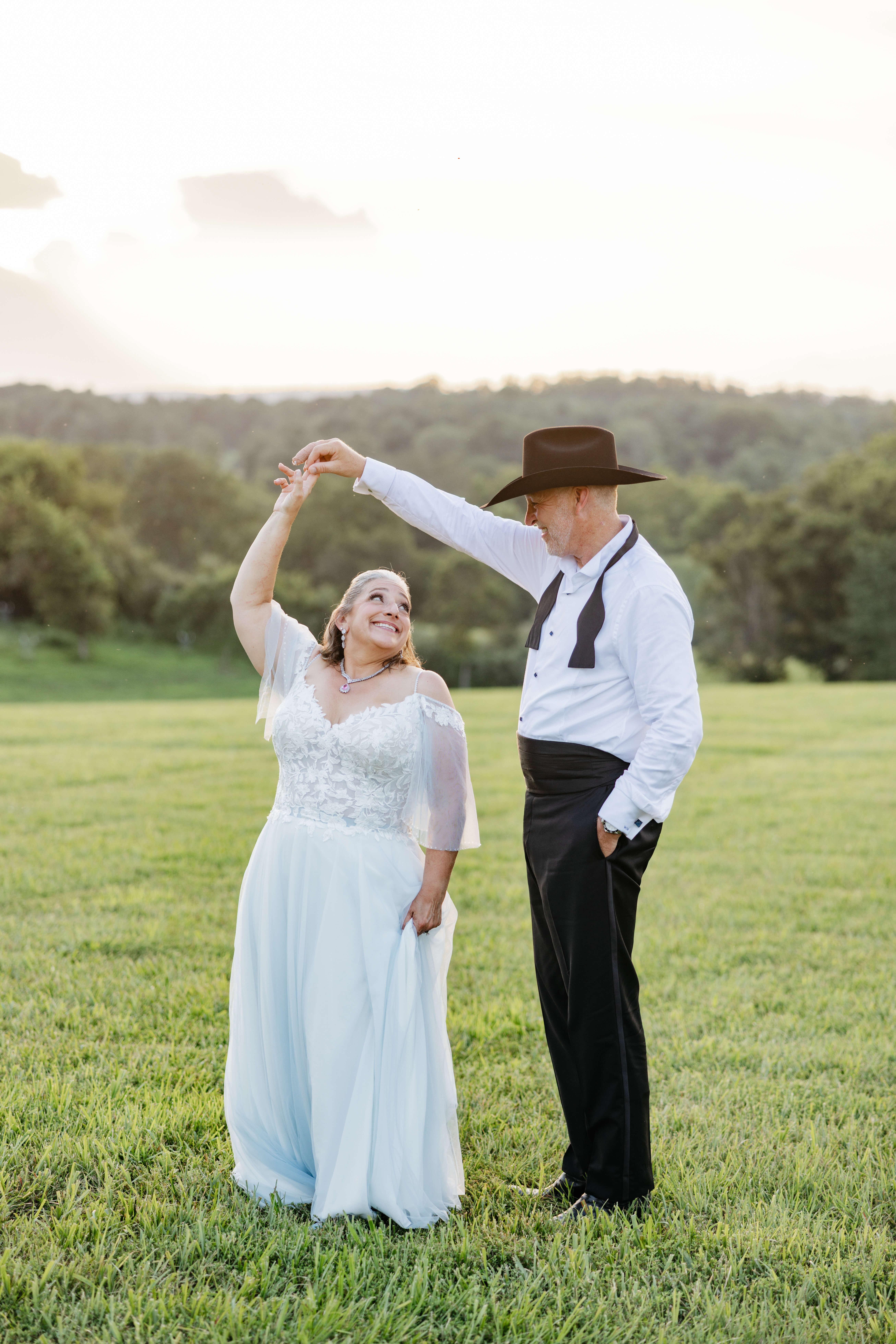 Private Residence Summer Wedding 36 Bride and groom dancing in the grass on their property smiling at one another