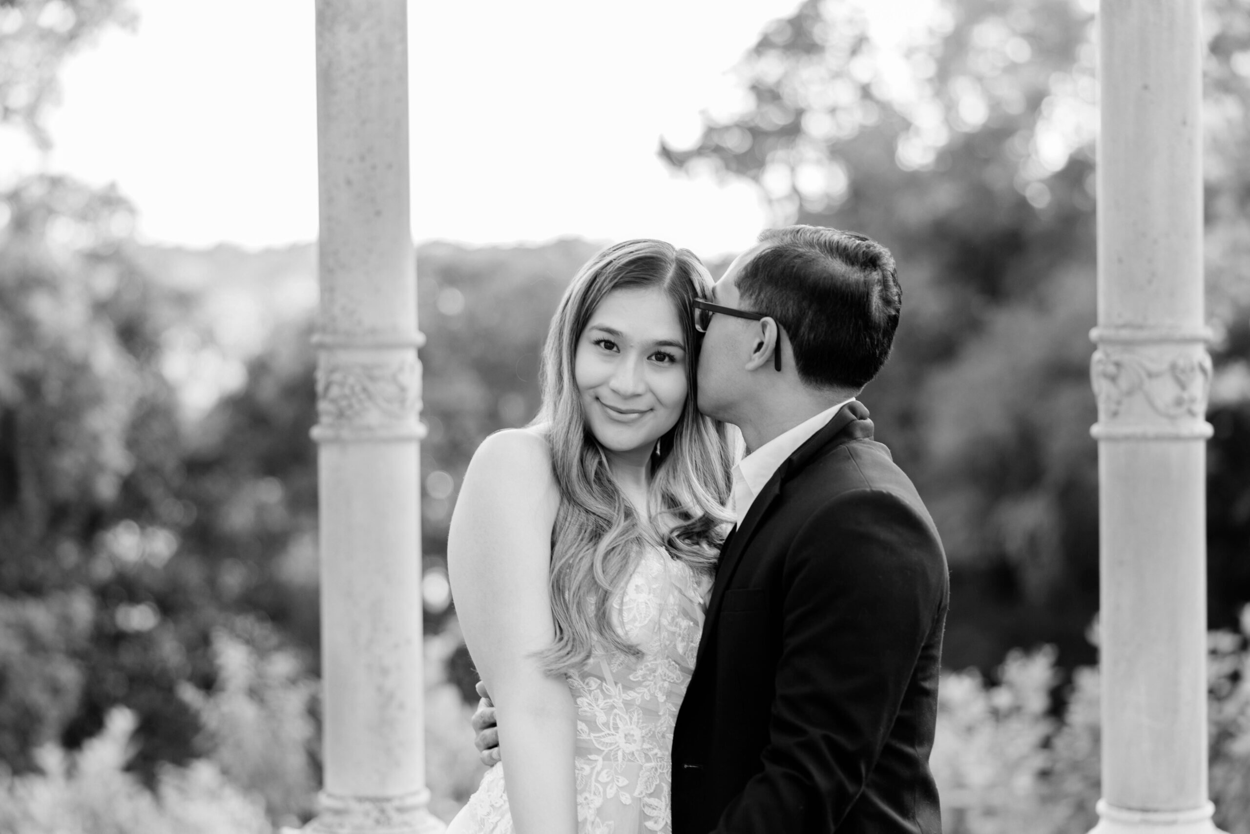 Maymont Park Engagement Summer Photography 7 Black and white photo of man kissing woman's head as she smiles at camer