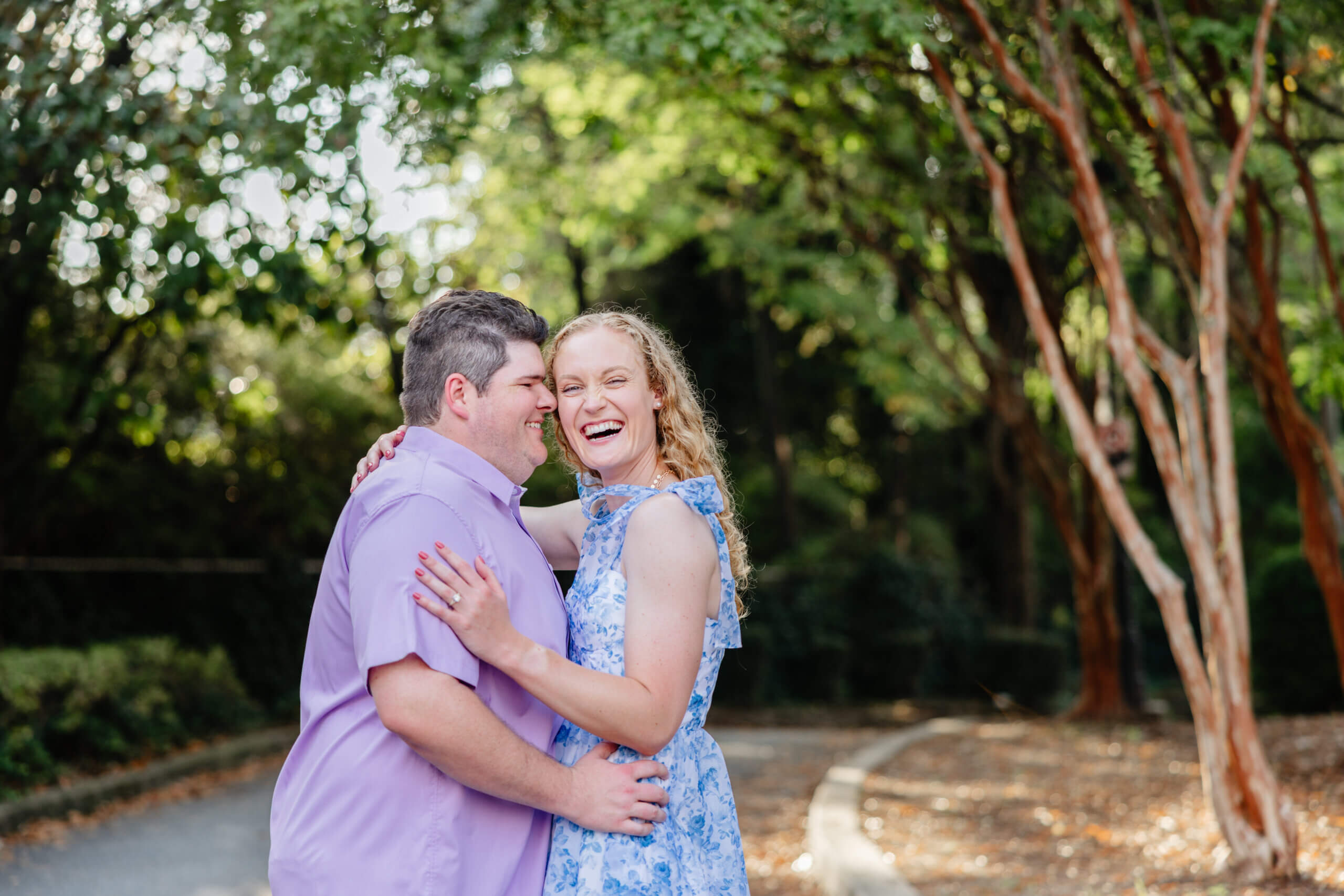 Shockhoe Bottom Fall Engagement Photography 16 Man and woman with their arms around each other, woman smiling at camera as man smiles with his nose touching her face
