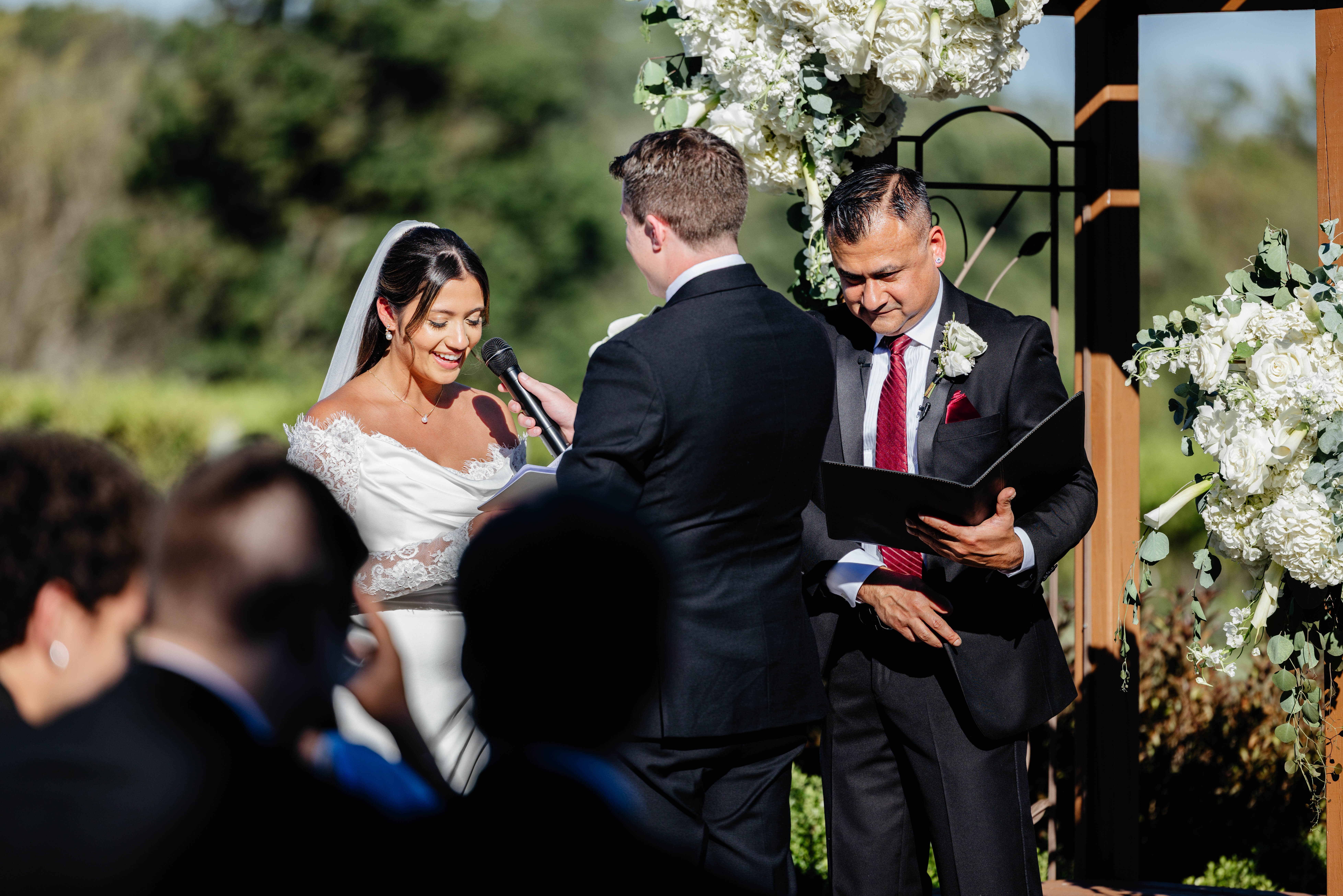CrossKeys Vineyard Fall Wedding Photography 21 Groom holding microphone for bride as she reads her vows at their outdoor crosskeys vineyard ceremony