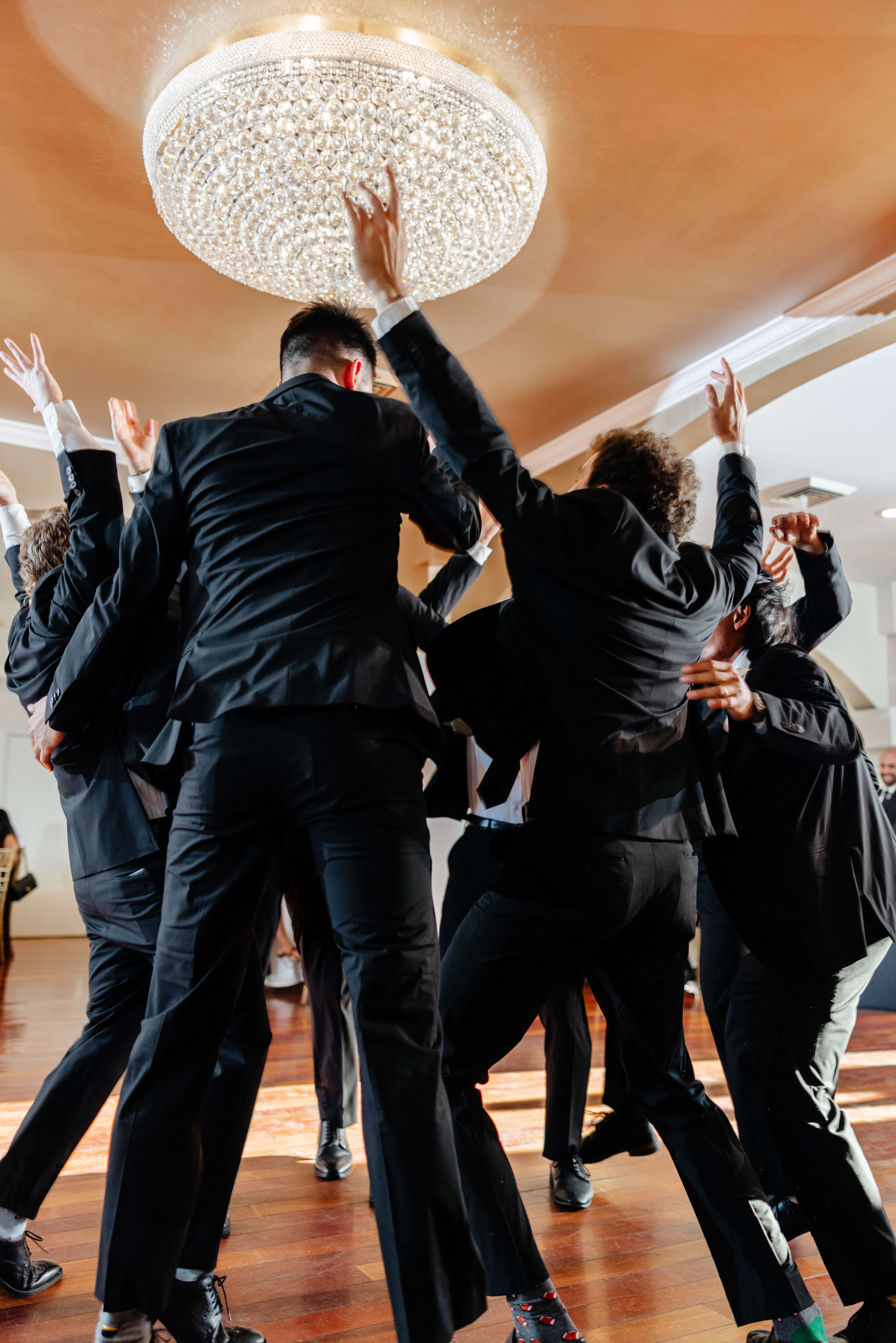 CrossKeys Vineyard Fall Wedding Photography 30 Groomsmen in circle huddle with arms thrown up in the air in celebration as they enter the reception