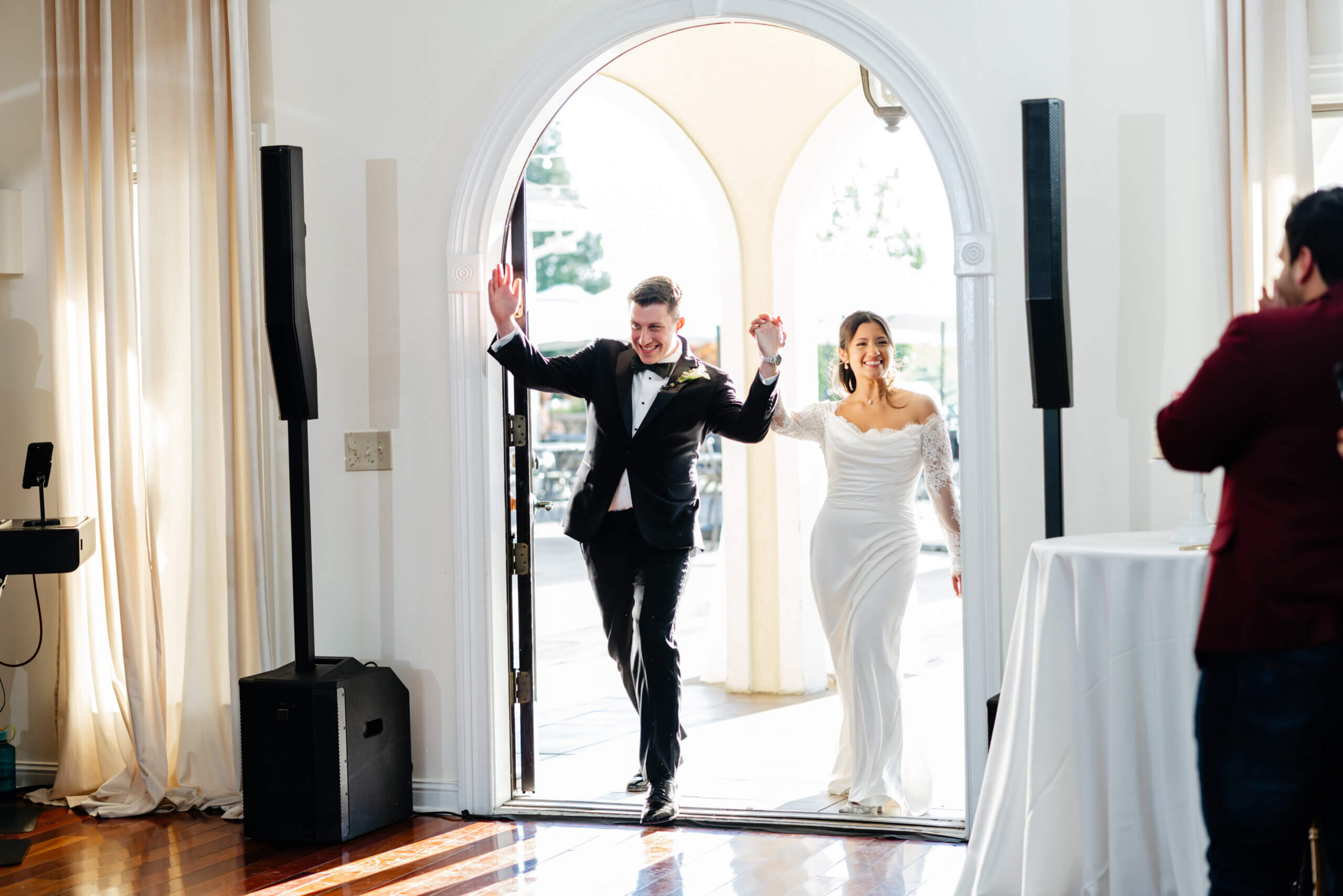 CrossKeys Vineyard Fall Wedding Photography 33 Bride and groom enter reception holding hands tossed up in the air smiling