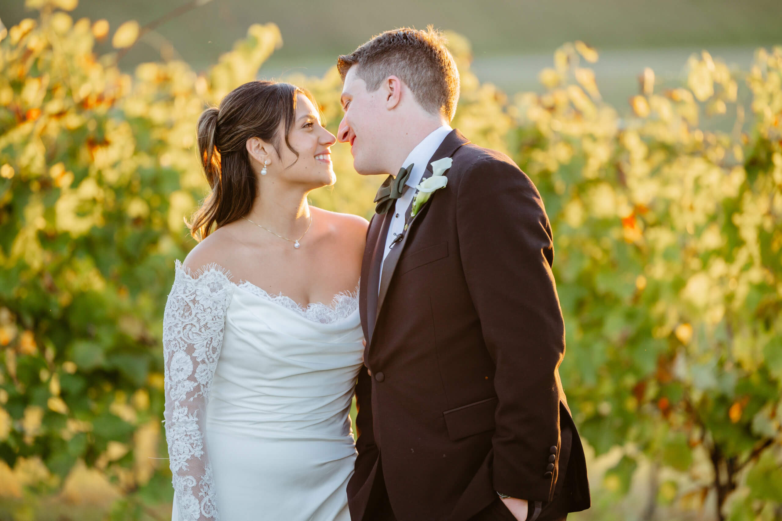 CrossKeys Vineyard Fall Wedding Photography 42 Close up photo of bride and groom smiling at one another leaning in towards each other, greenery in background