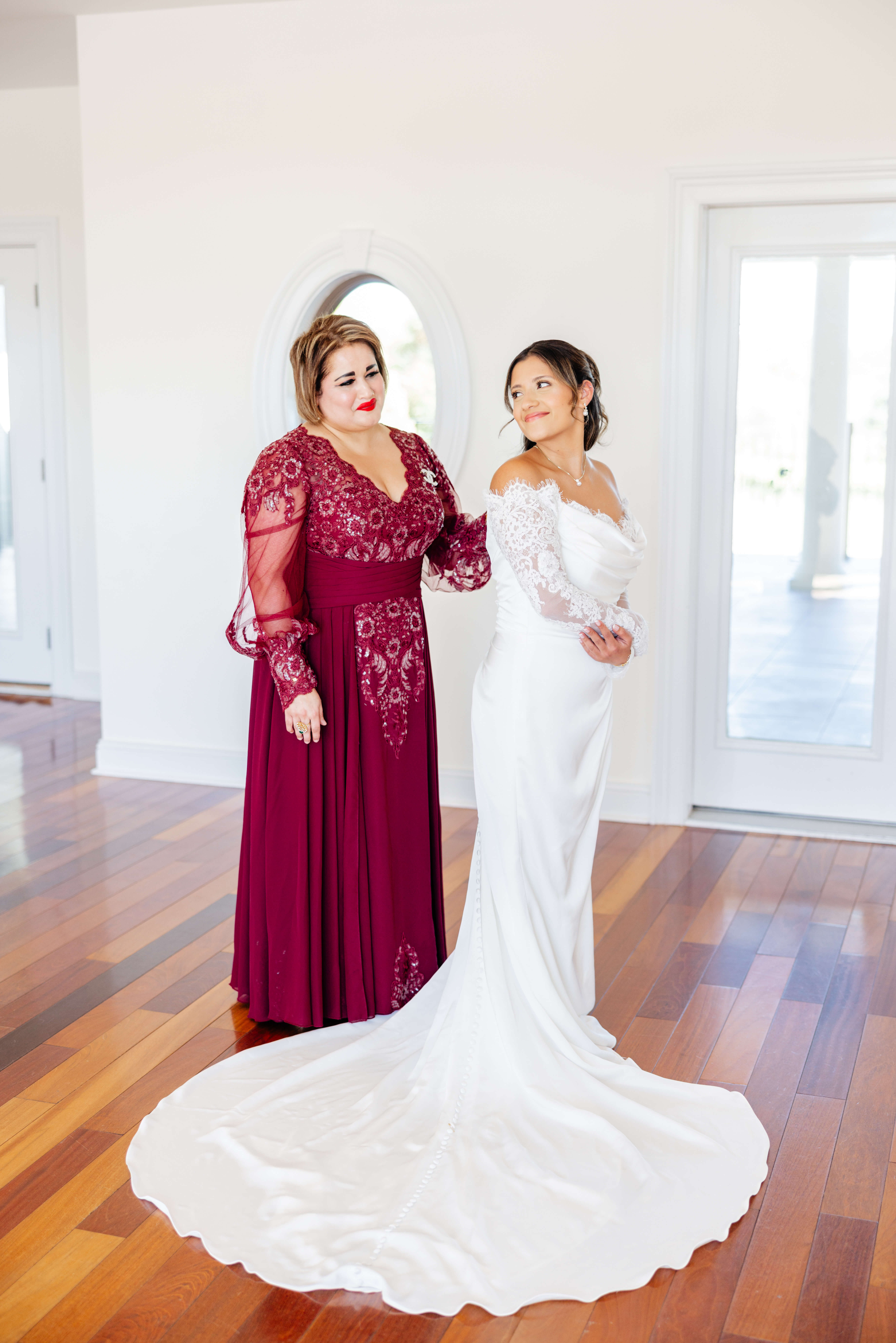 CrossKeys Vineyard Fall Wedding Photography 5 Bride in her wedding dress looks over her shoulder to smile at her mom who stands behind her in wine colored dress