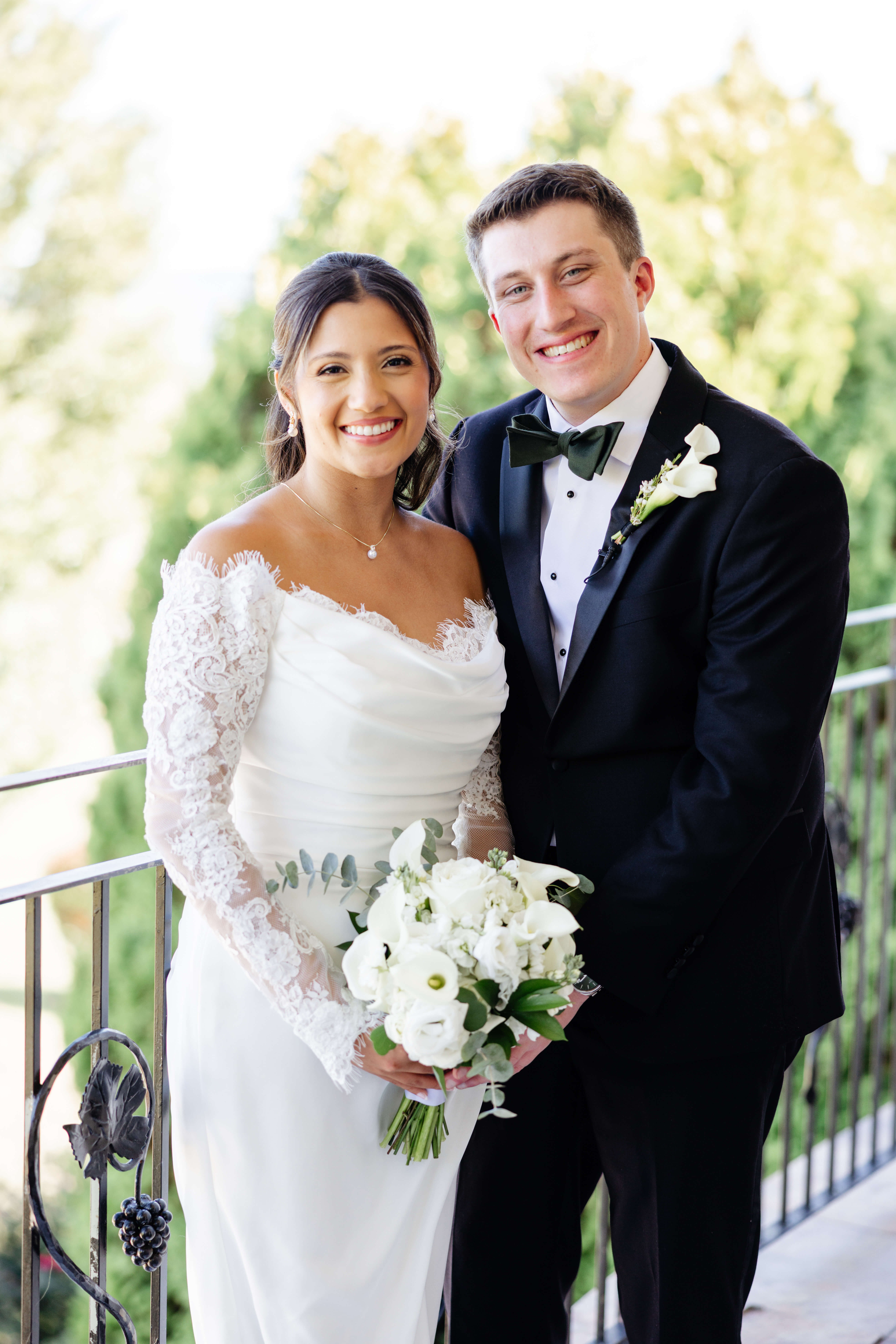 CrossKeys Vineyard Fall Wedding Photography 15 Bride and groom stand next to each other both smiling at camera as bride holds a bouquet of white flowers