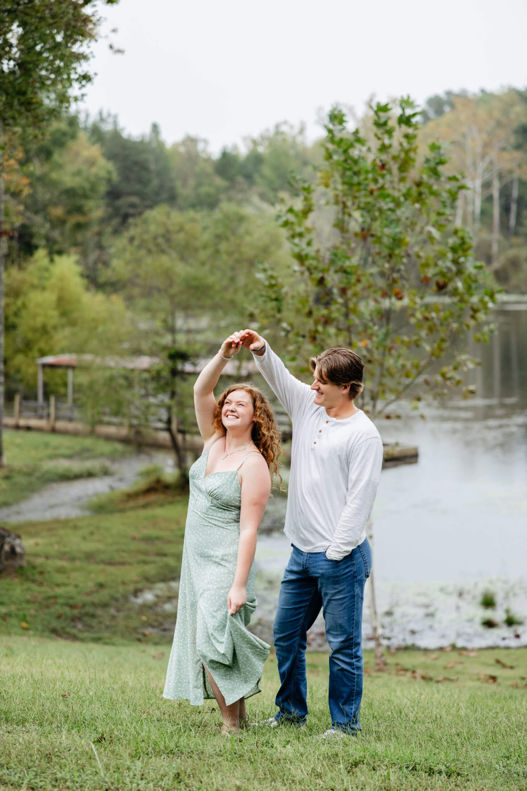Rassawek Vineyards Fall Engagement Photography 11 Woman twirling around as she holds her fiance's hand, he smiles at her as she dances