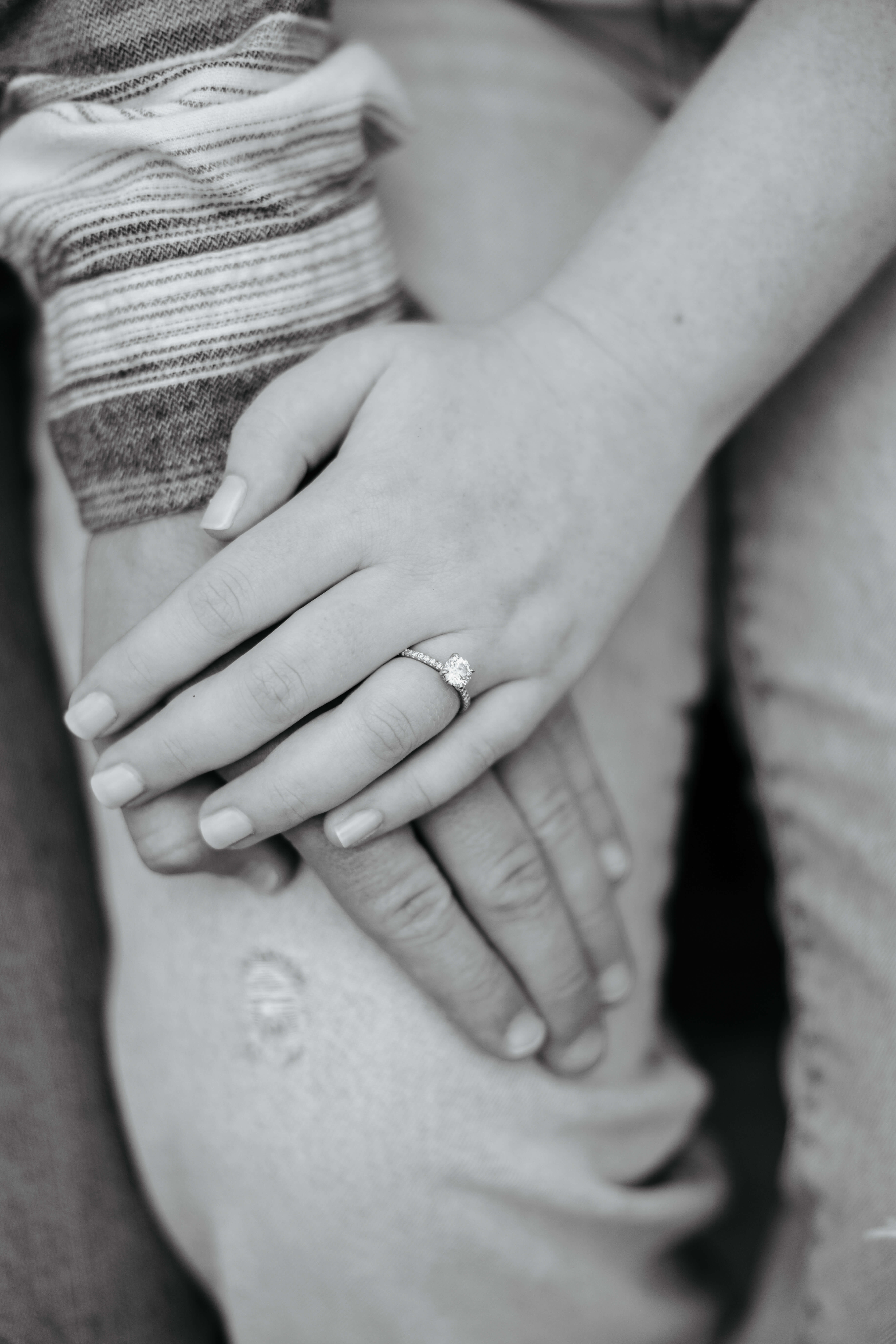 Rassawek Vineyards Fall Engagement Photography 17 Black and white photo of woman's left hand on top of her fiance's hand to show off her diamond engagement ring