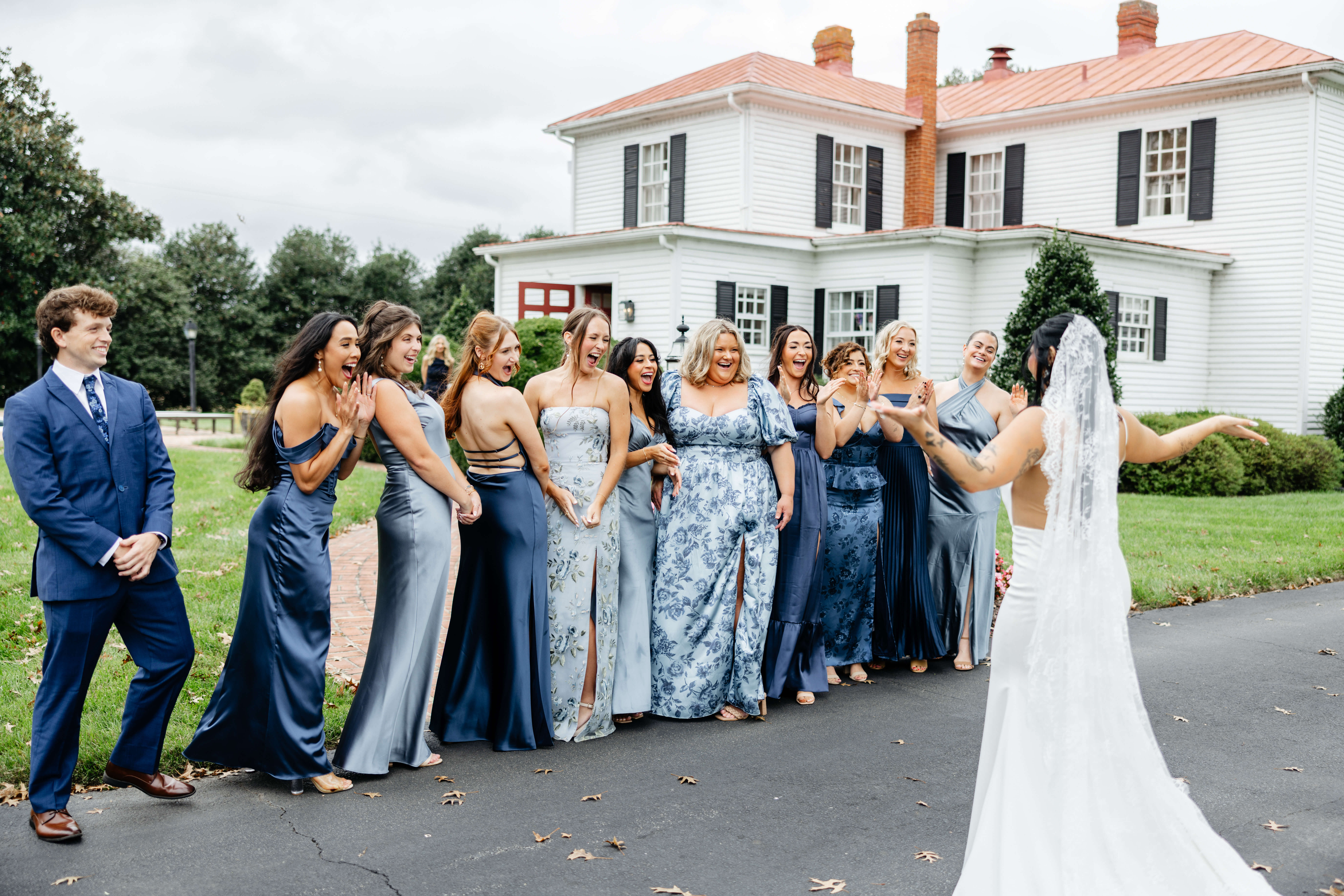 Barns of Kanak October Wedding 22 Bride holding her arms out in a 'ta da!' position as her bridal party turns around, smiles on their faces as they see her in her dress