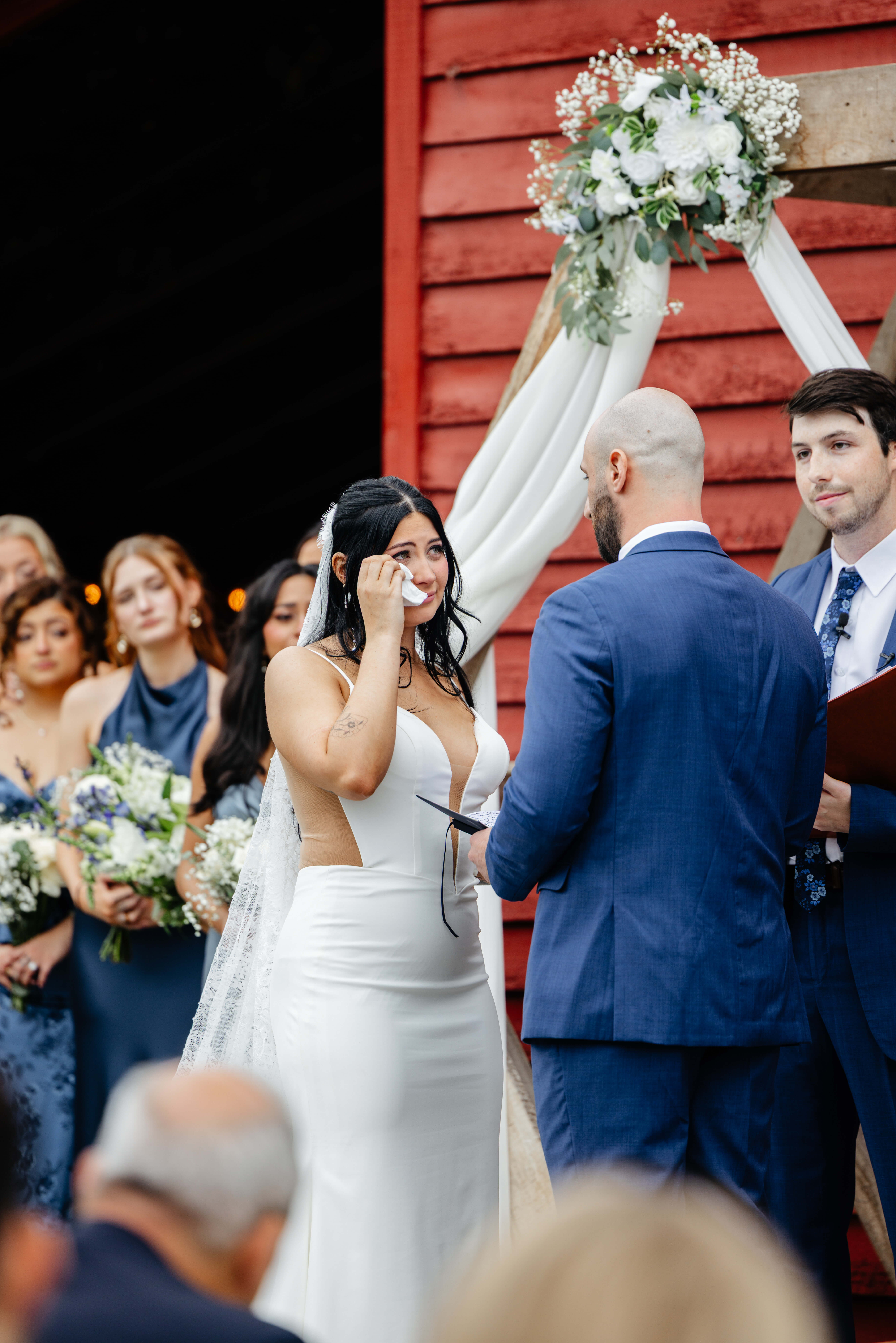 Barns of Kanak October Wedding 29 Bride wiping a tear from her eye with emotional expression on her face as groom reads his vows