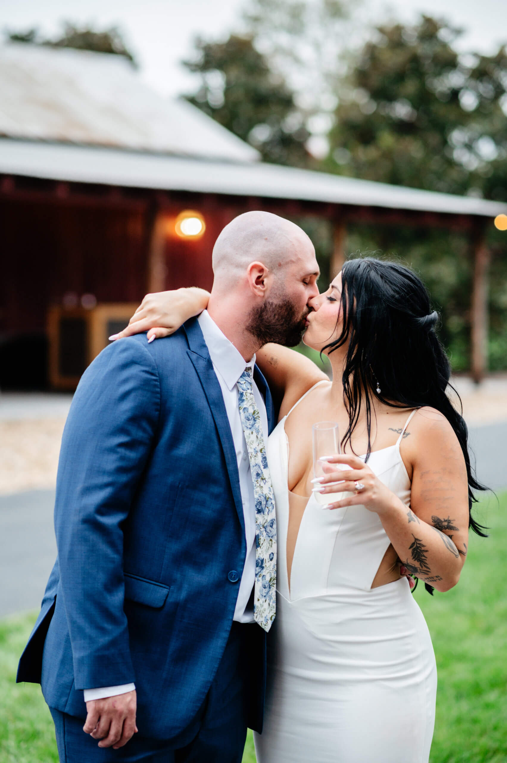 Barns of Kanak October Wedding 43 Bride and groom share a kiss outside as bride holds champagne glass