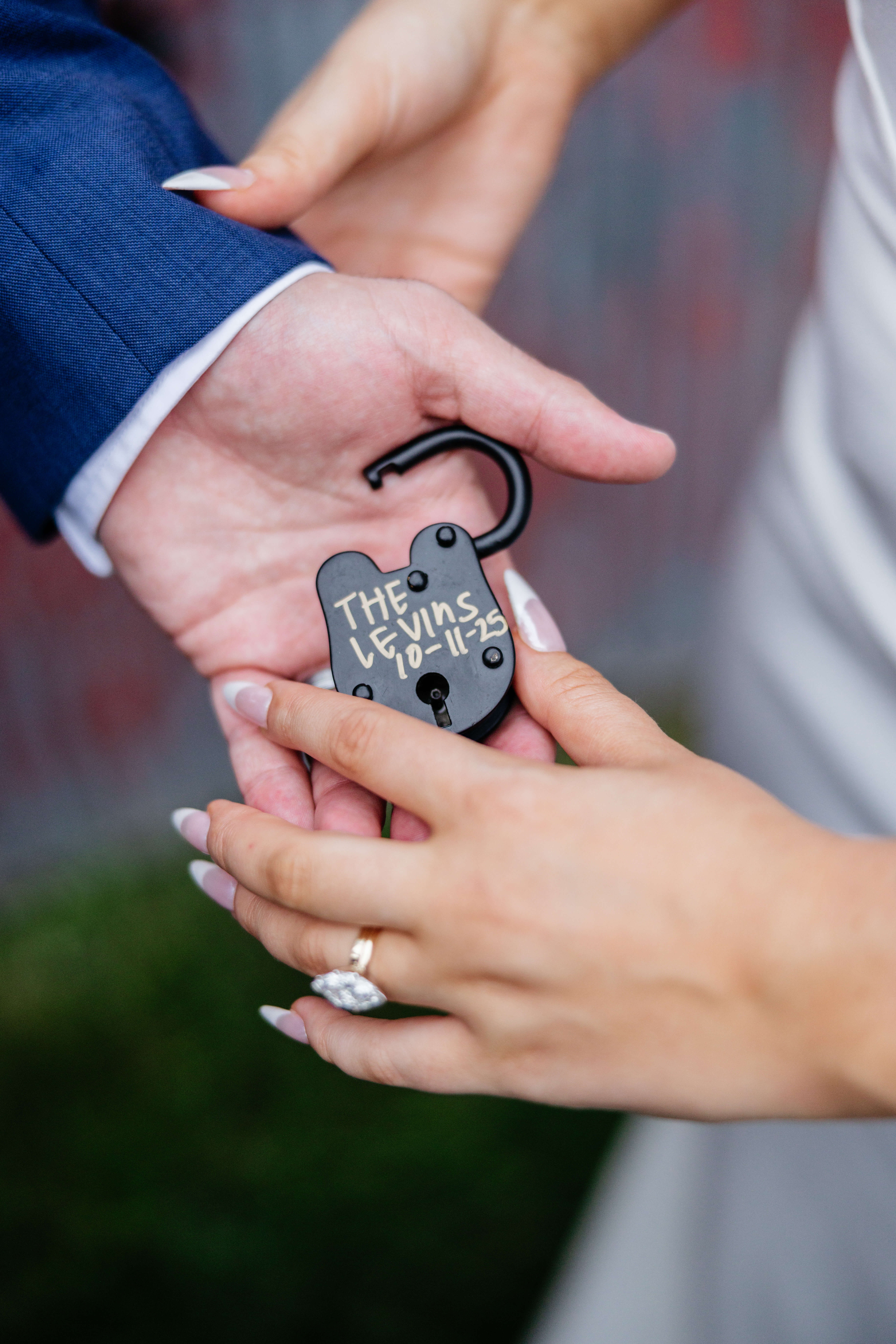 Barns of Kanak October Wedding 47 Small black lock sits open in groom's hand that reads The Levins 10-11025