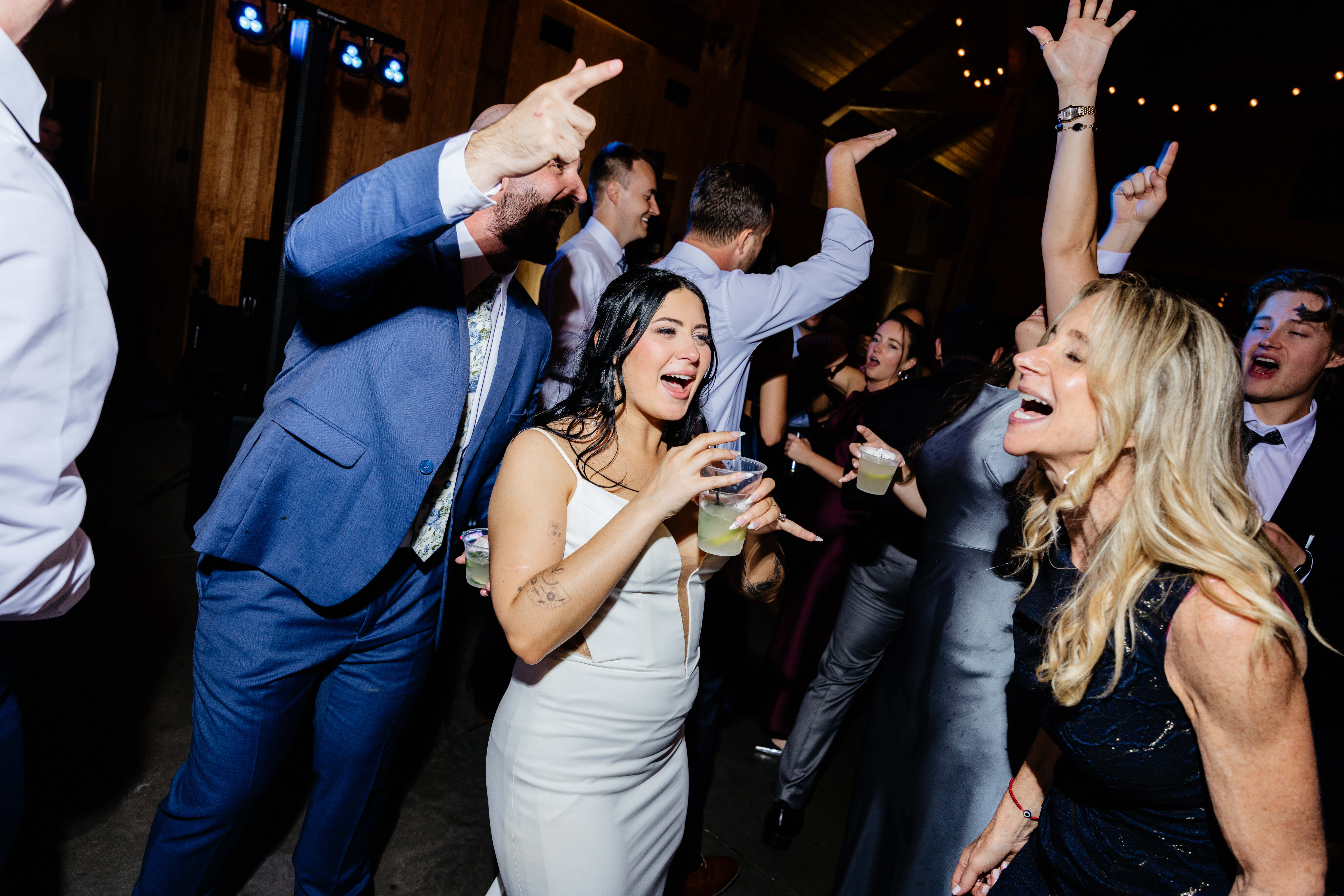 Barns of Kanak October Wedding 54 Bride and groom dancing and singing on dance floor with their wedding guests, bride holding drink in clear solo cup