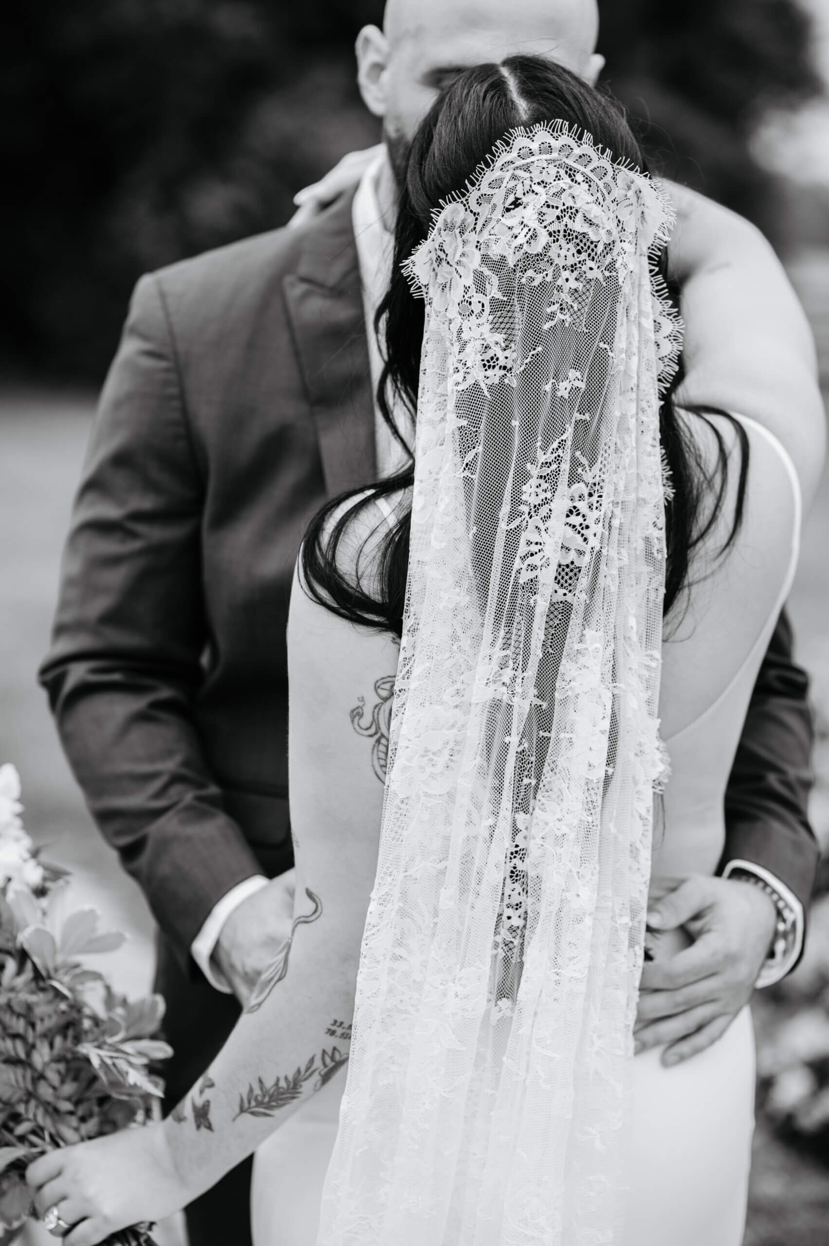 Barns of Kanak October Wedding 17 Black and white detail photo of bride's veil as she wraps an arm around groom's back