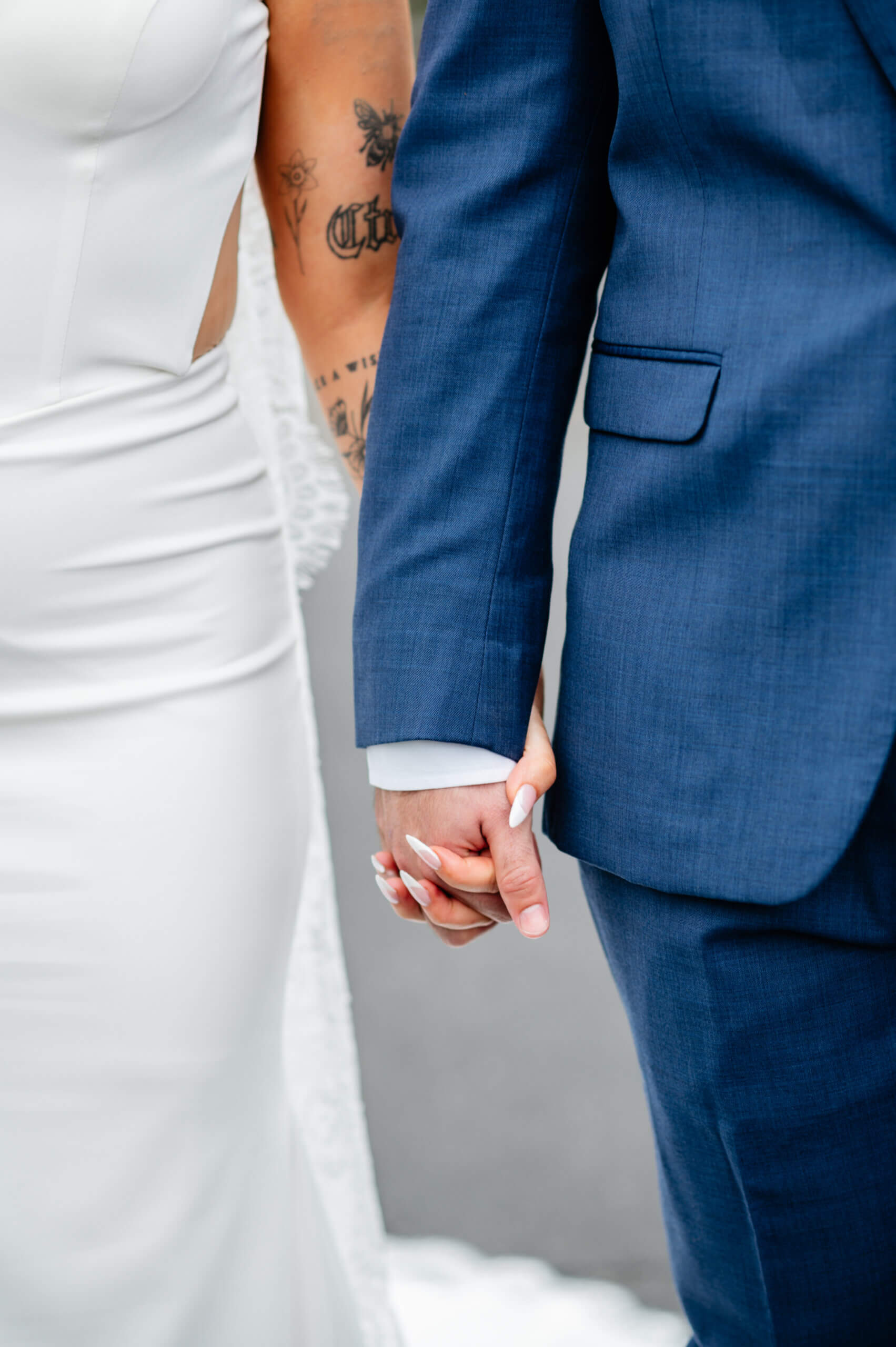Barns of Kanak October Wedding 18 Close up photo of bride and groom's arms and hands as they hold hands, some of bride's various arm tattoos visable in photo