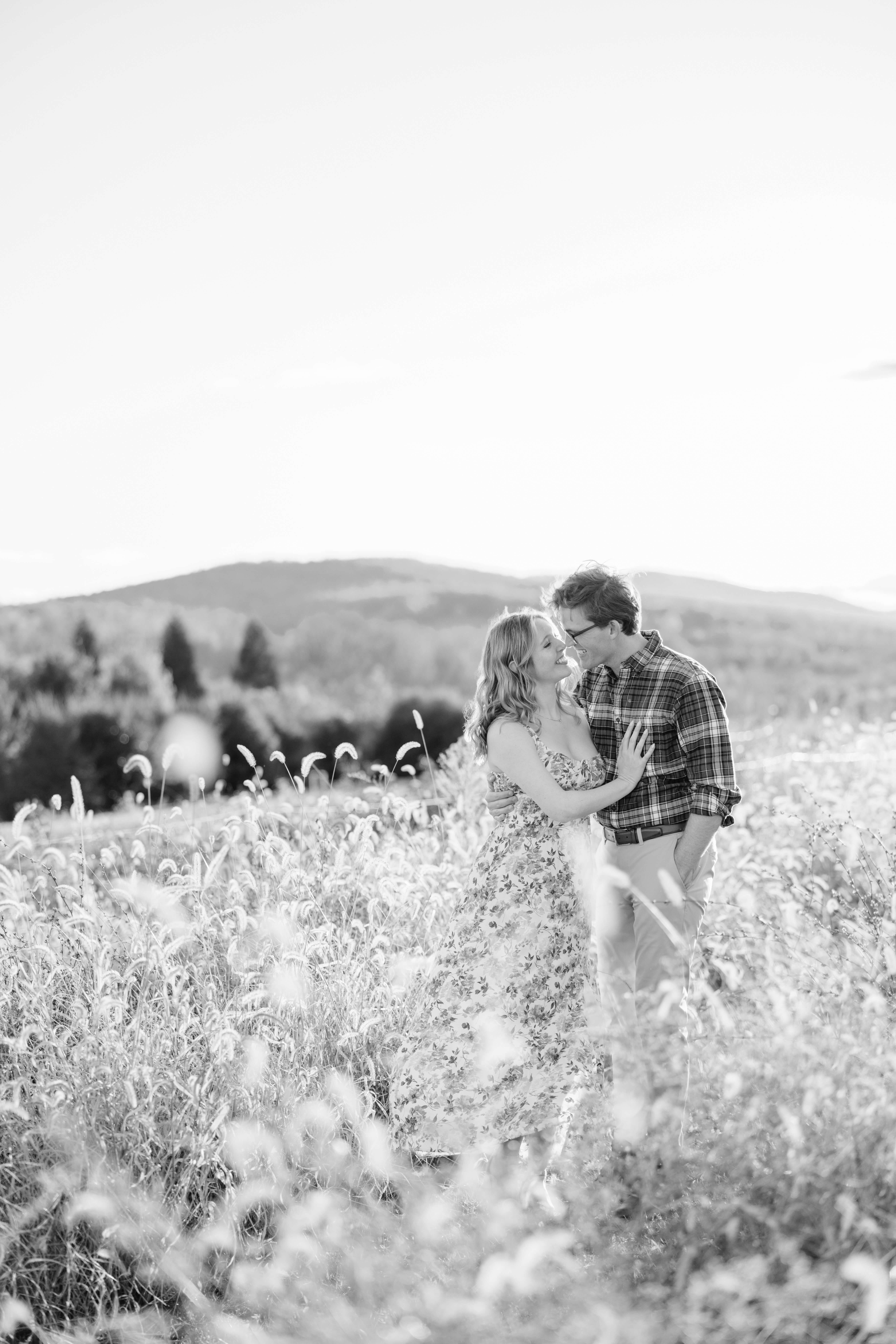 Market at Grelen Fall Engagement Photography 20 Black and white photo of engaged couple smiling at one another leaning in for a kiss, woman's hand resting on man's chest