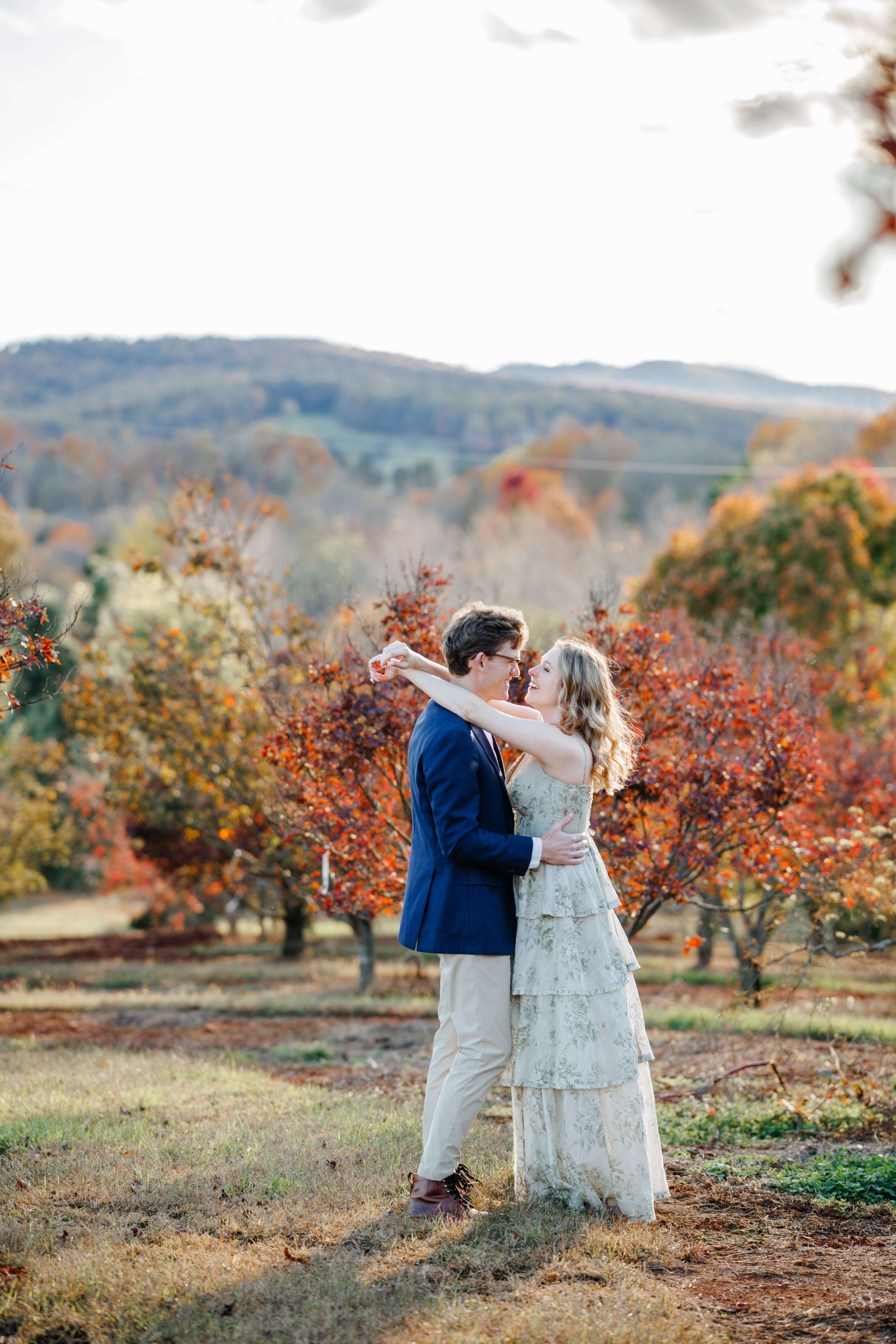 Market at Grelen Fall Engagement Photography 3 Engaged couple smiling at one another, man holding woman's hips as she drapes her arms behind his neck