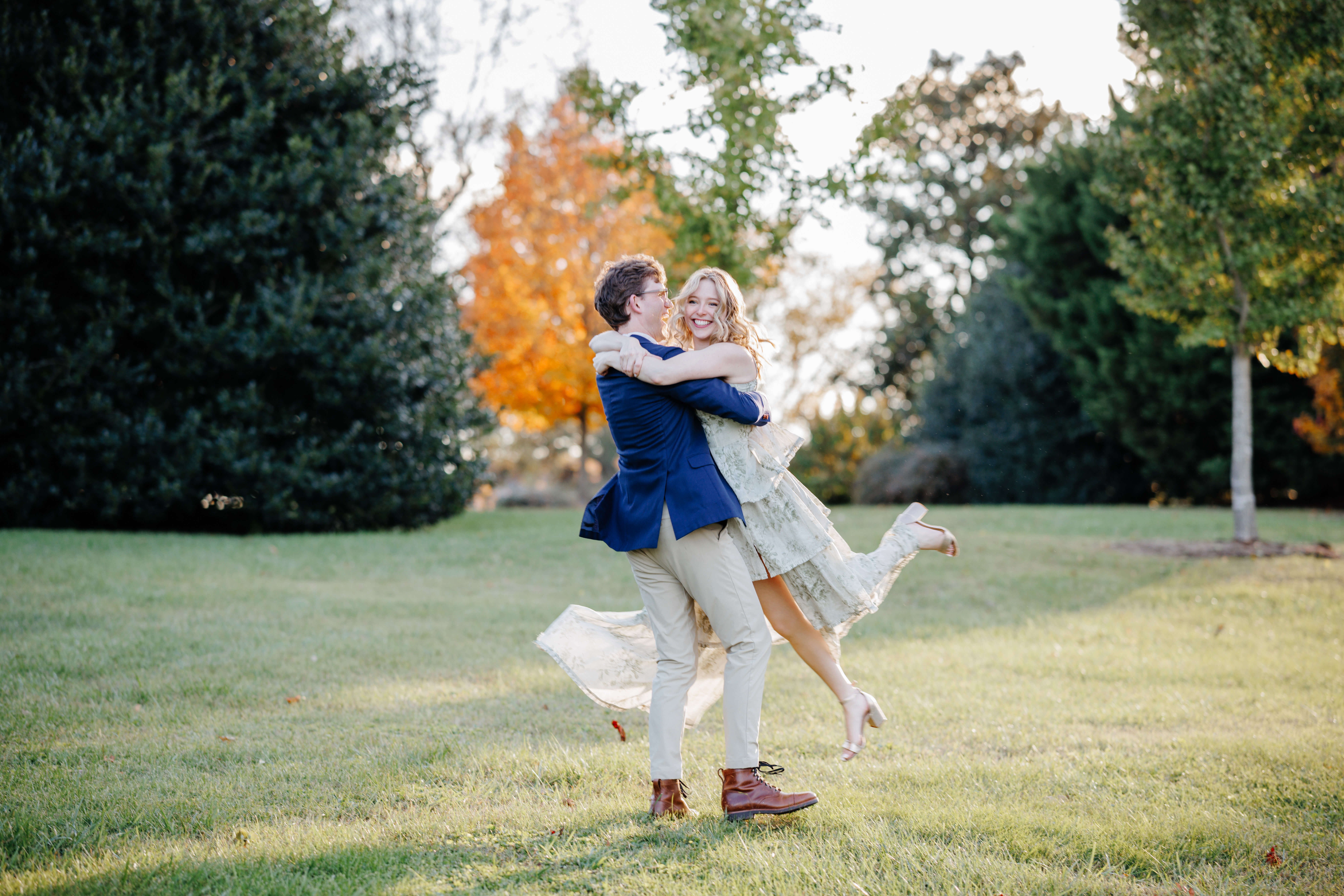 Market at Grelen Fall Engagement Photography 8 Man spins woman around as she wraps her arms around him both smiling and laughing