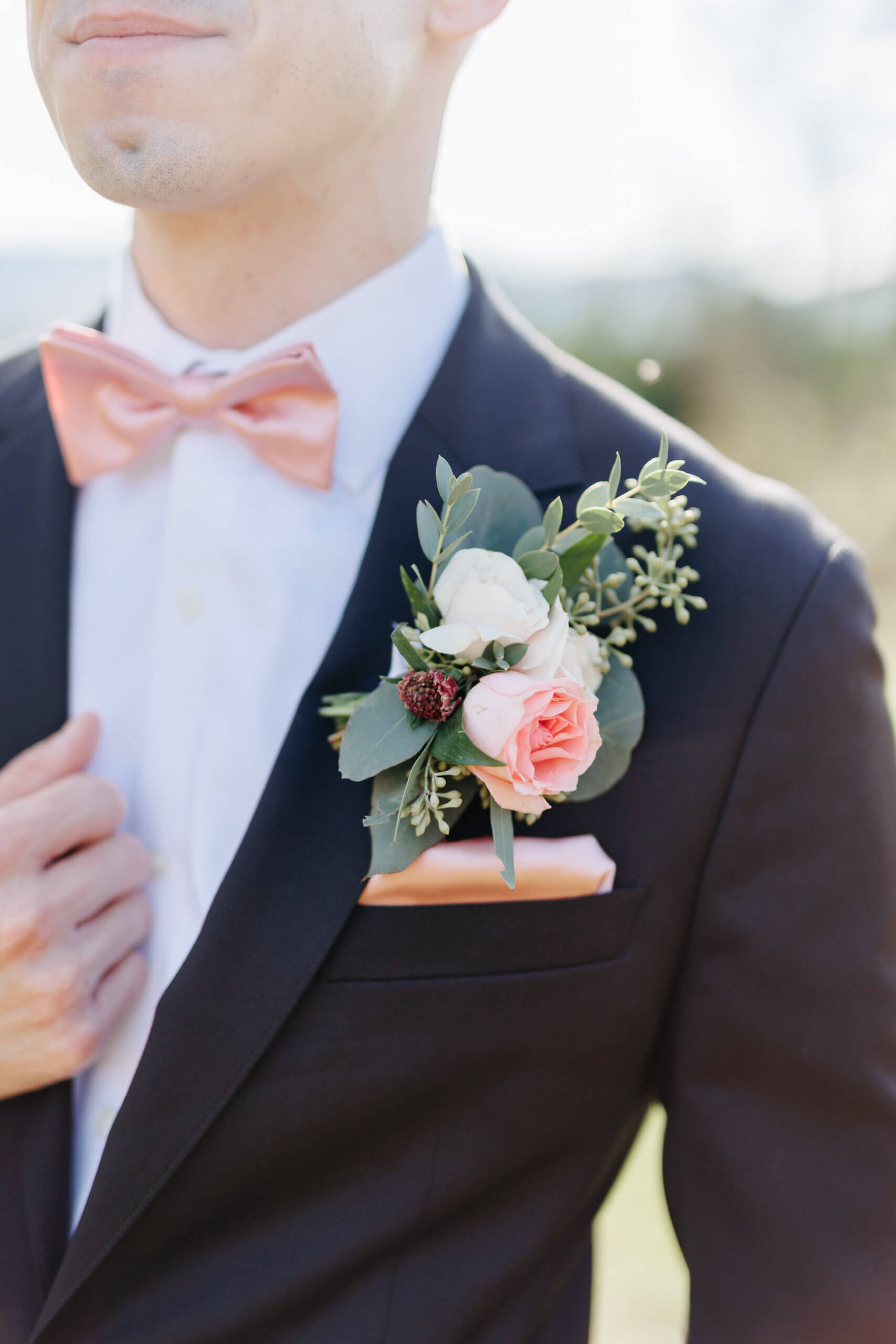 Valley Road Vineyard Fall Wedding 16 Detail photo of groom's boutonniere with greenery and pink flowers