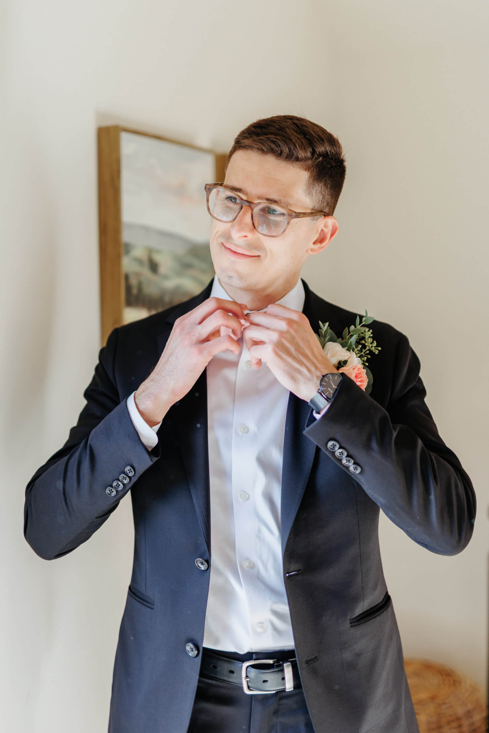 Valley Road Vineyard Fall Wedding 17 Groom adjusting his bowtie as he looks off to side with a slight smile on his face