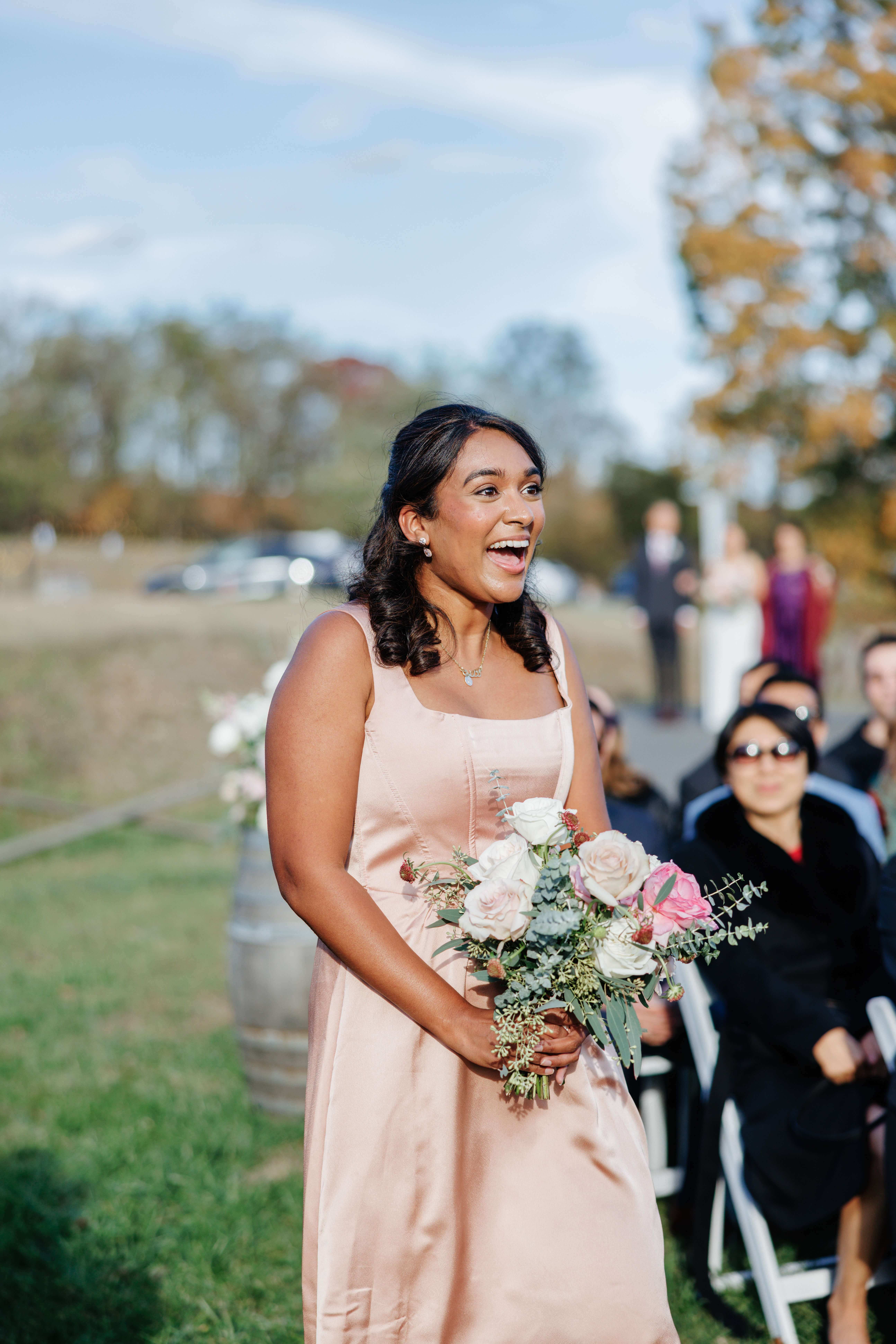 Valley Road Vineyard Fall Wedding 20 One of the bridesmaids walking down aisle with an excited expression as she looks toward groom