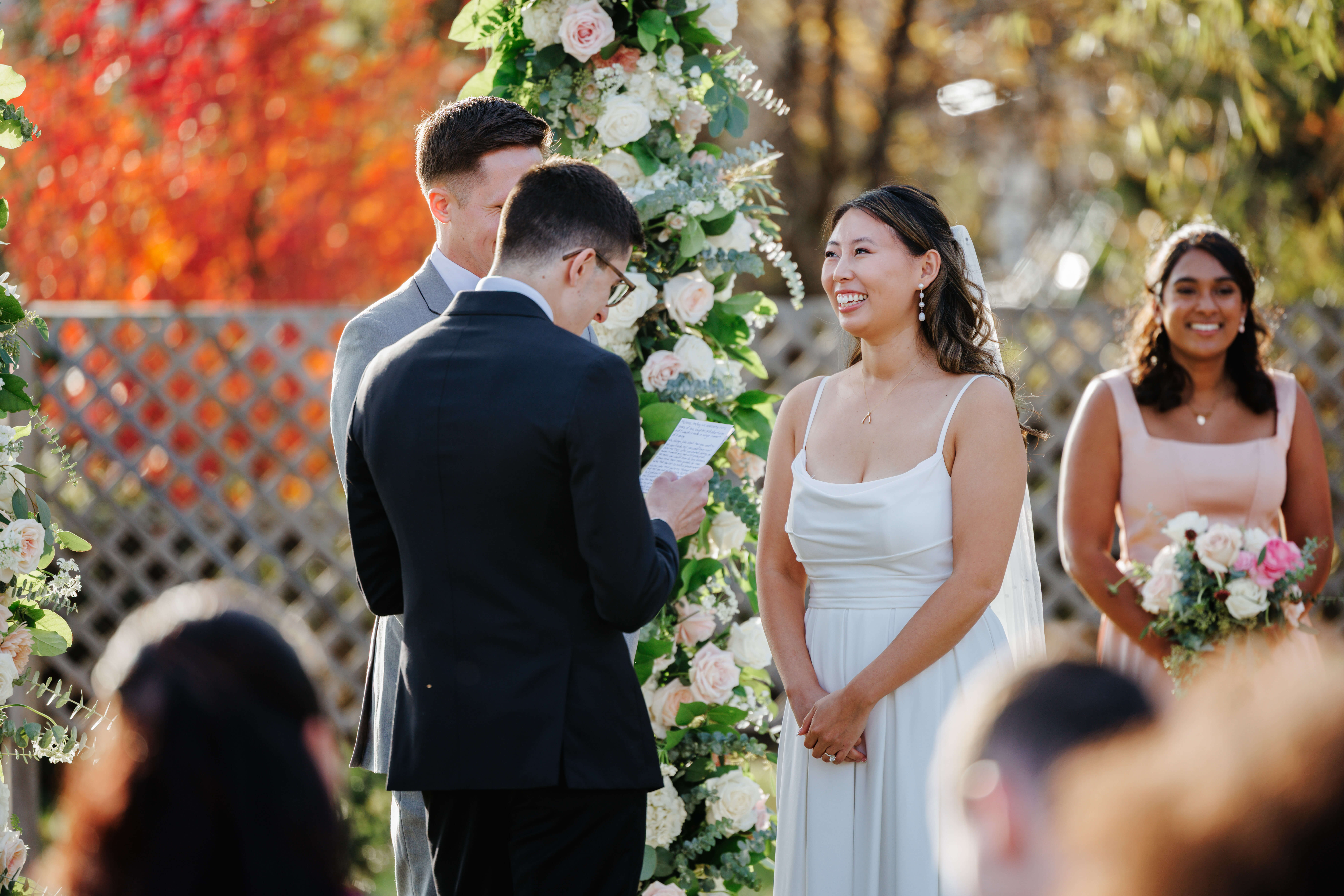 Valley Road Vineyard Fall Wedding 27 Bride smiling as groom reads his vows