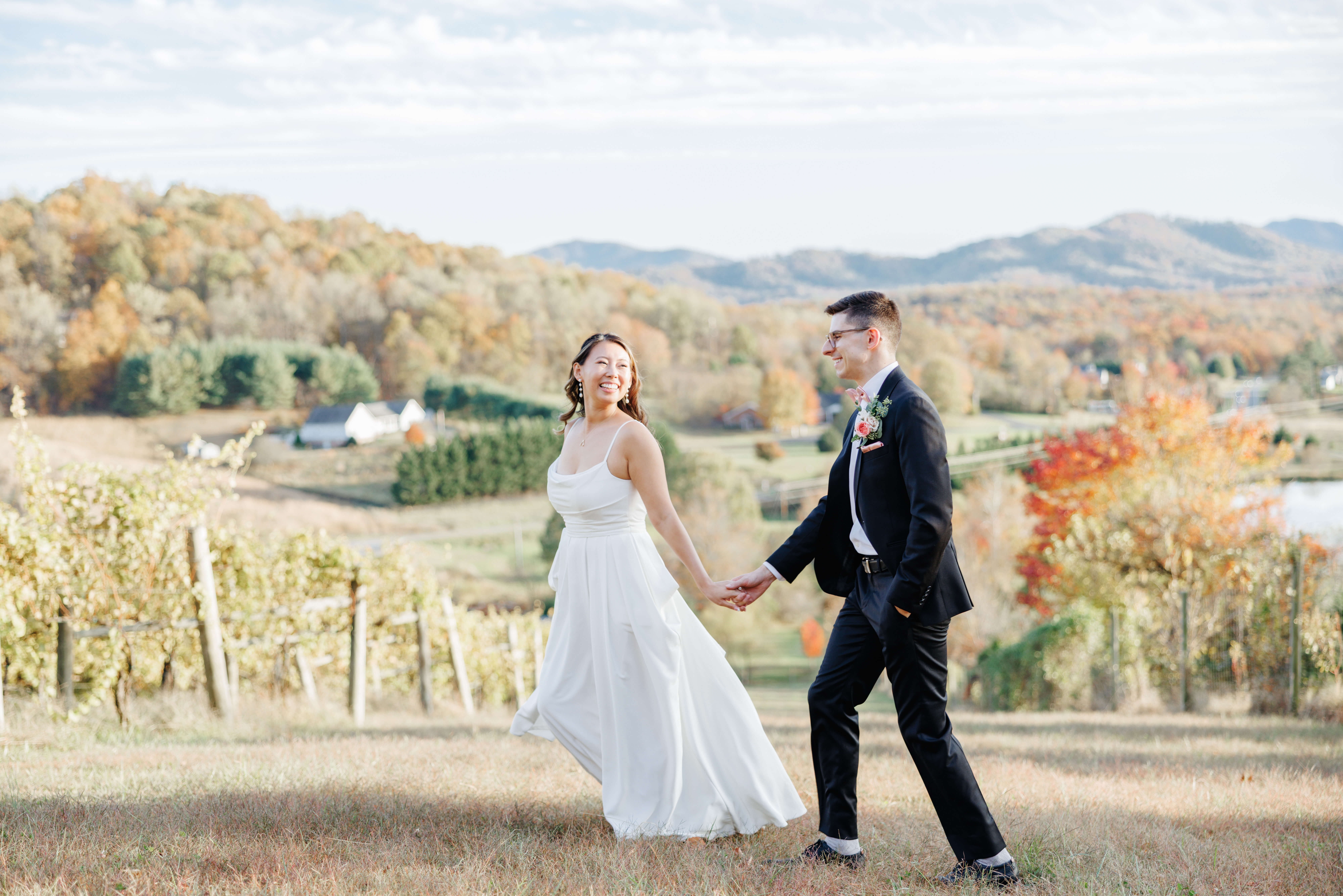 Valley Road Vineyard Fall Wedding 35 Bride walking ahead of groom looking back at him smiling and holding his hand