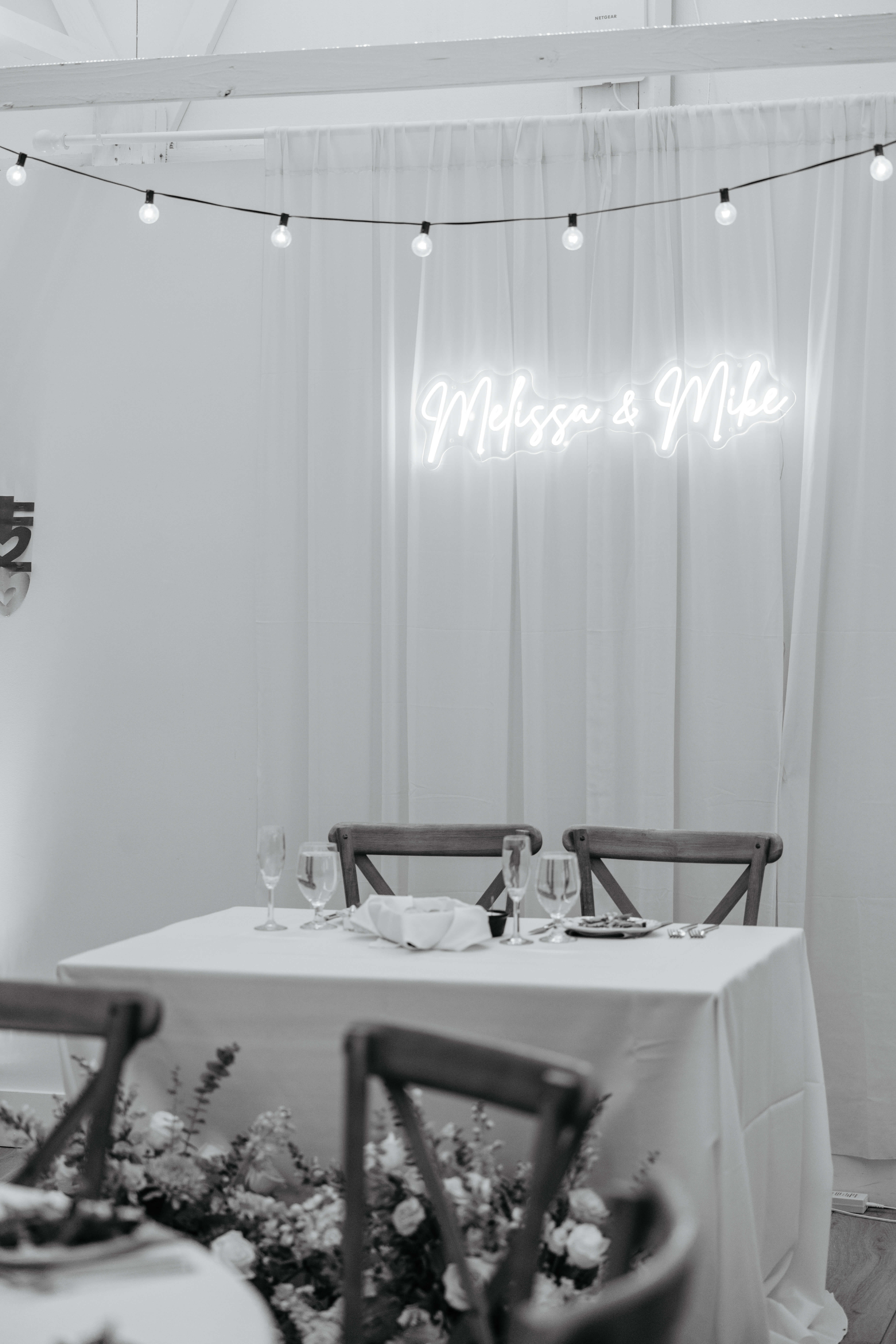Valley Road Vineyard Fall Wedding 38 Black and white photo of sweetheart table with light up sign that says melissa and mike