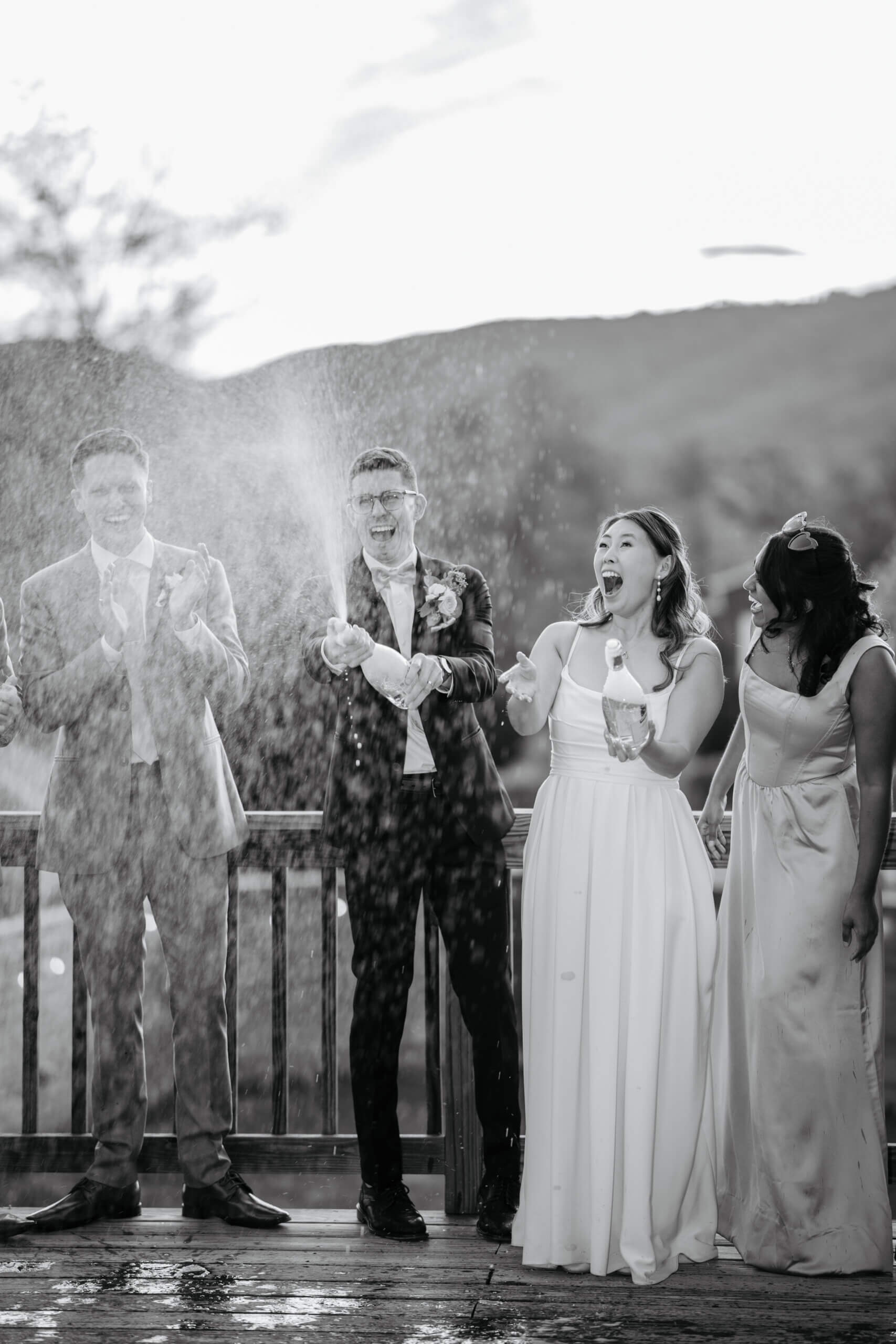 Valley Road Vineyard Fall Wedding 40 Black and white photo of groom popping champagne and bride with surprised and excited expression on her face