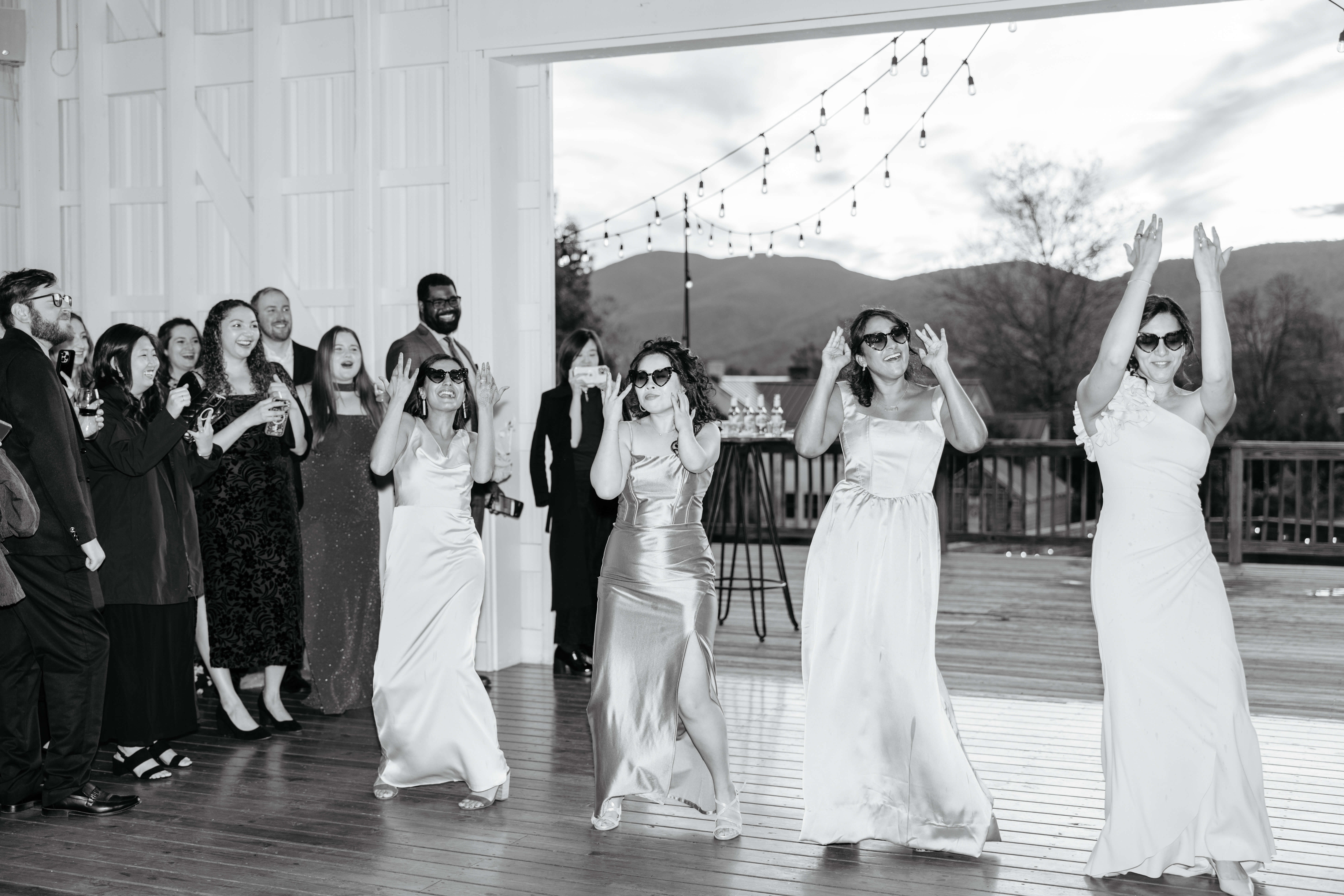 Valley Road Vineyard Fall Wedding 41 Black and white photo of bridesmaids entering reception all dancing and wearing sunglasses