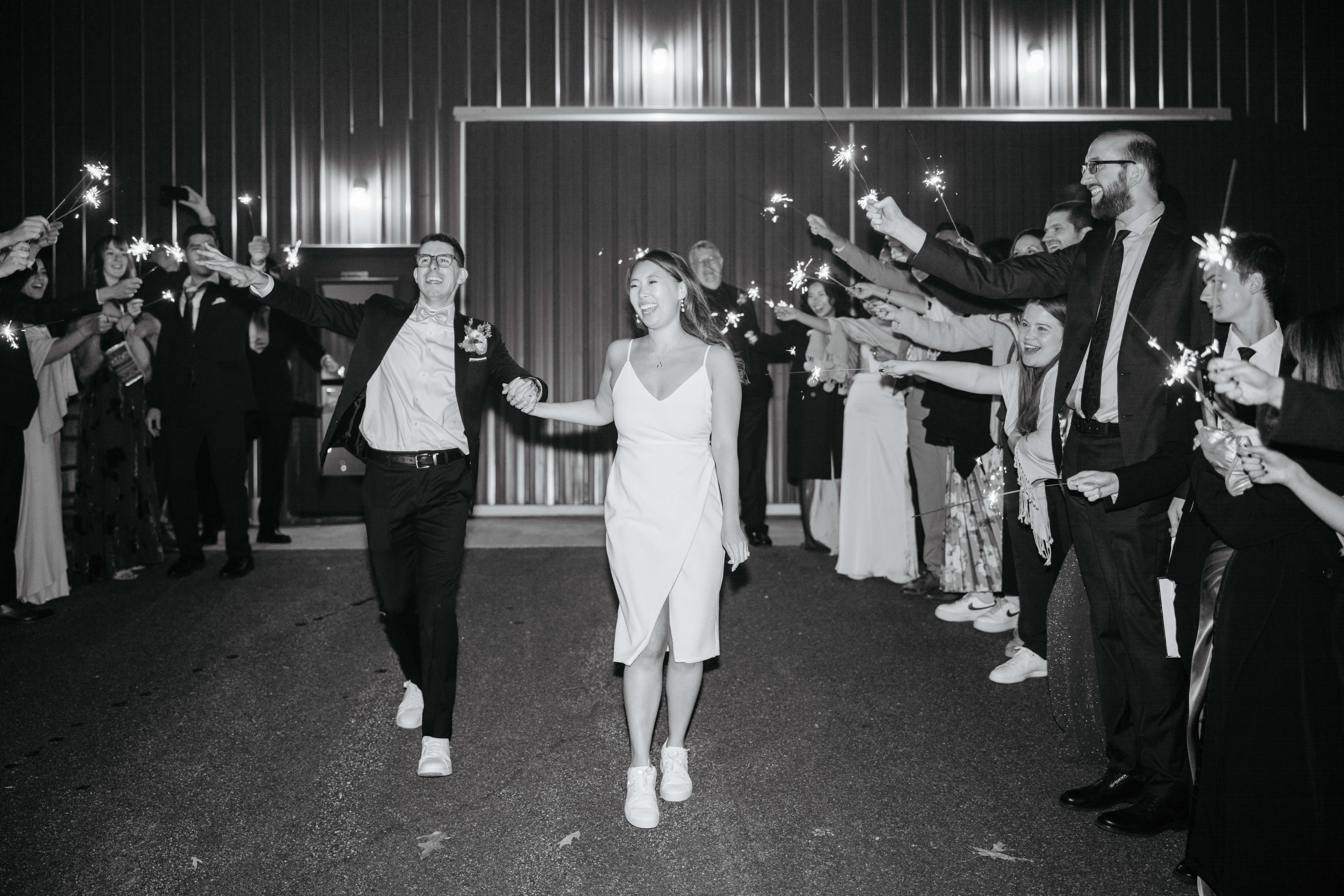 Valley Road Vineyard Fall Wedding 53 Black and white photo of bride and groom exiting their reception as guests hold out sparklers and cheer