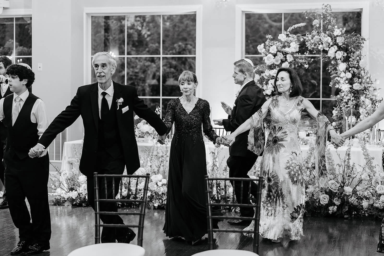 Poplar Springs Manor Spring Wedding Photography 34 black and white photo of guests holding hands in a circle