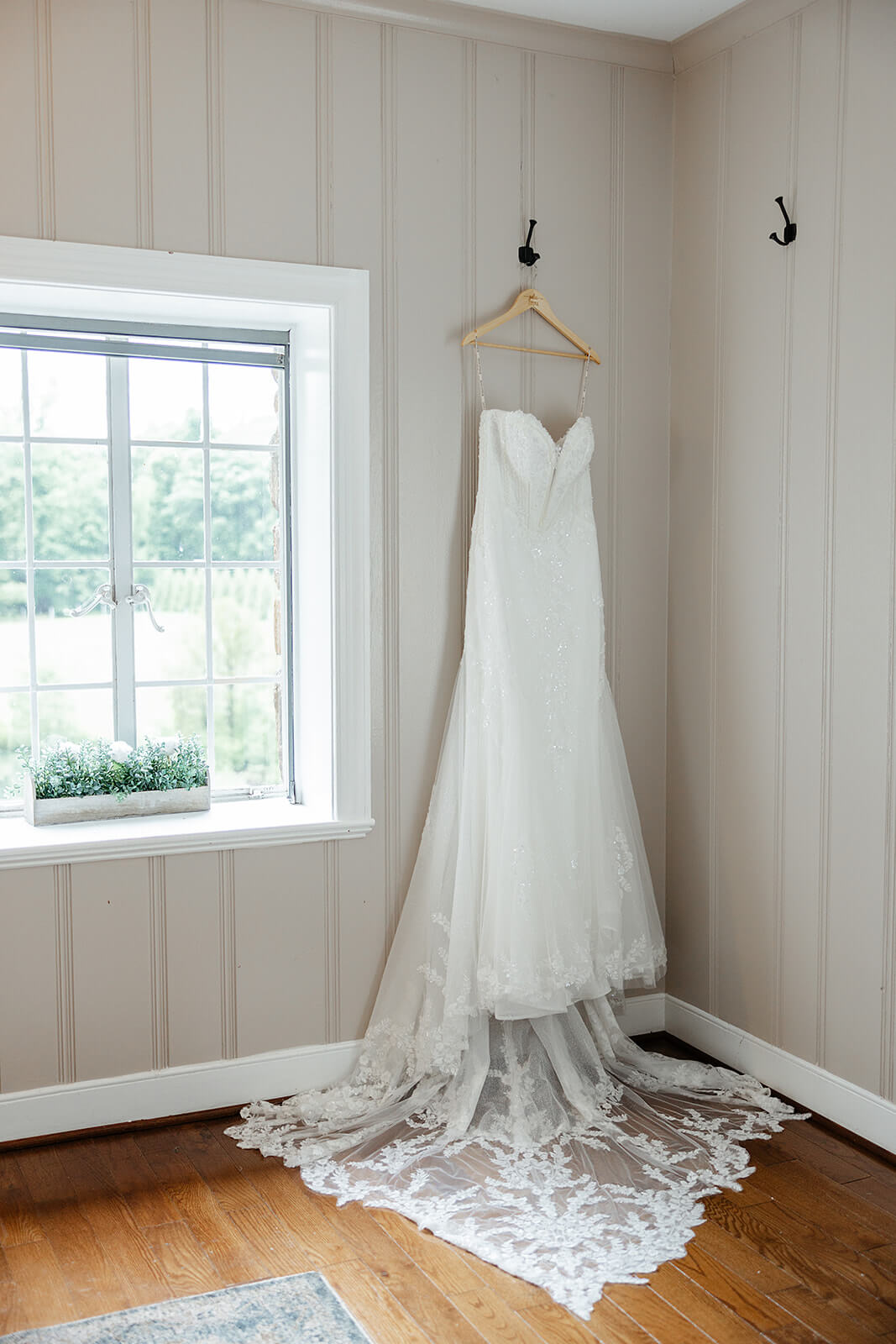 Poplar Springs Manor Spring Wedding Photography 2 brides dress hanging next to a large window with sunlight coming in