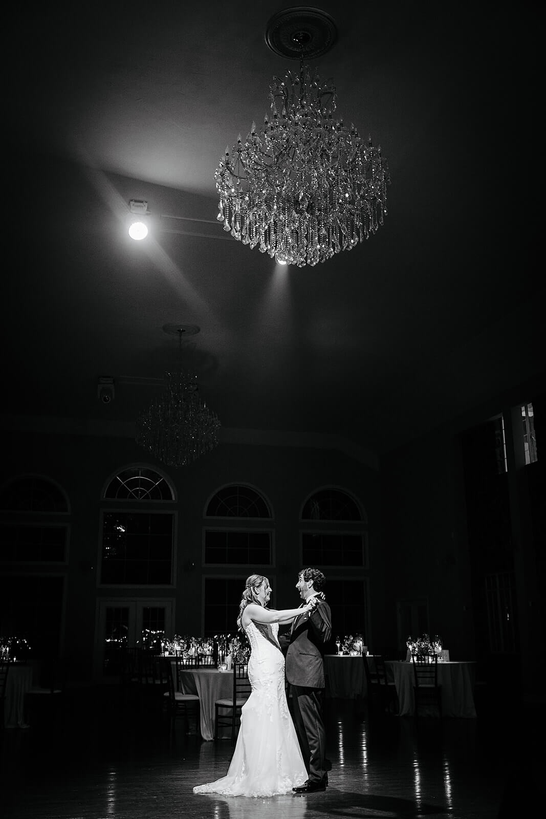 Poplar Springs Manor Spring Wedding Photography 52 black and white photo of bride and groom sharing a private dance under a large chandelier